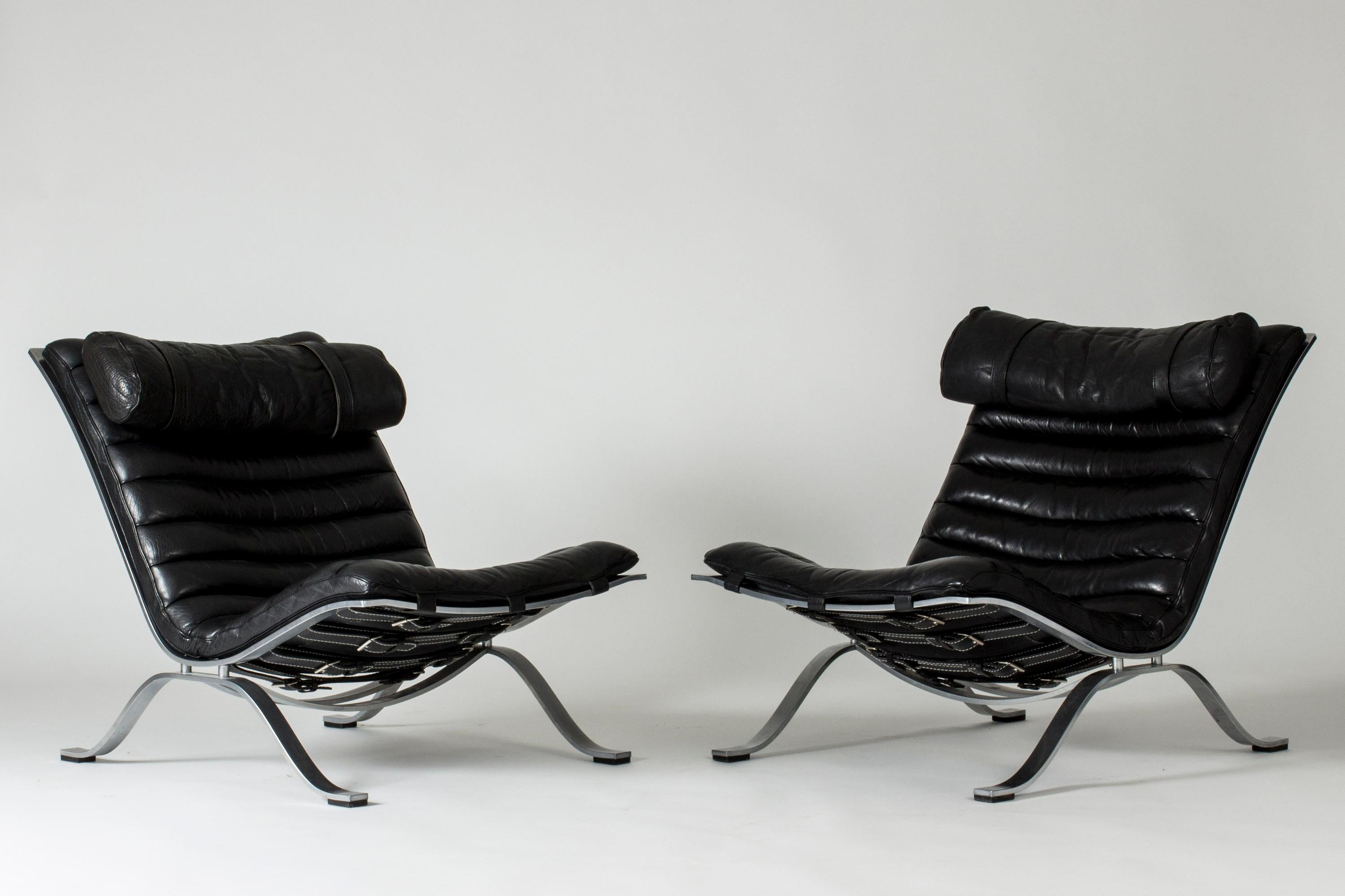 Pair of cool and comfortable “Ari” lounge chairs by Arne Norell, made from steel and leather. Beautiful black leather with nice patina.