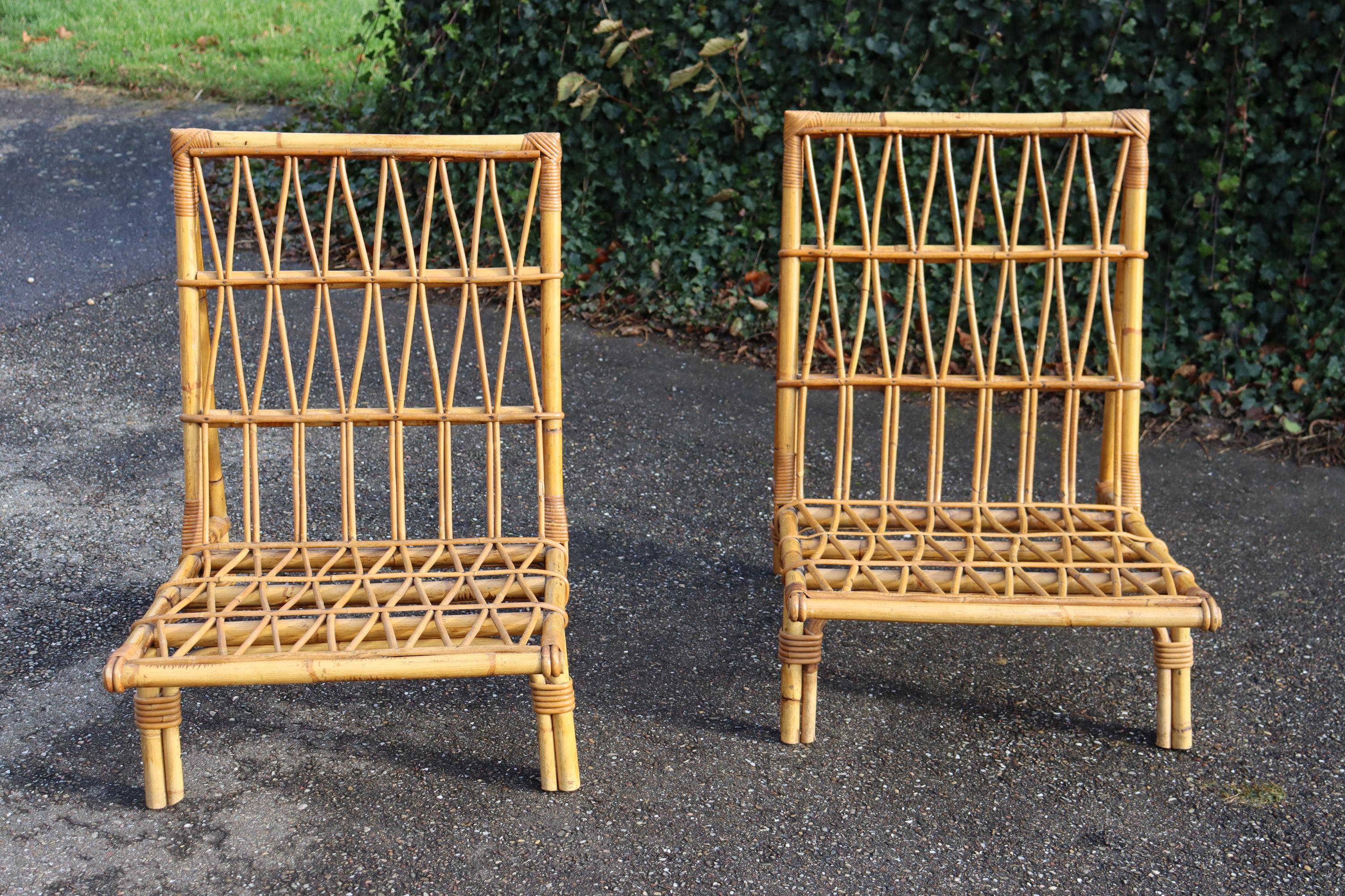 Pair of rattan lounge chairs, attributed to Audoux & Minnet. Circa 1950. Excellent overall condition, no missing pieces. Original varnish throughout. Seat height 29cm.