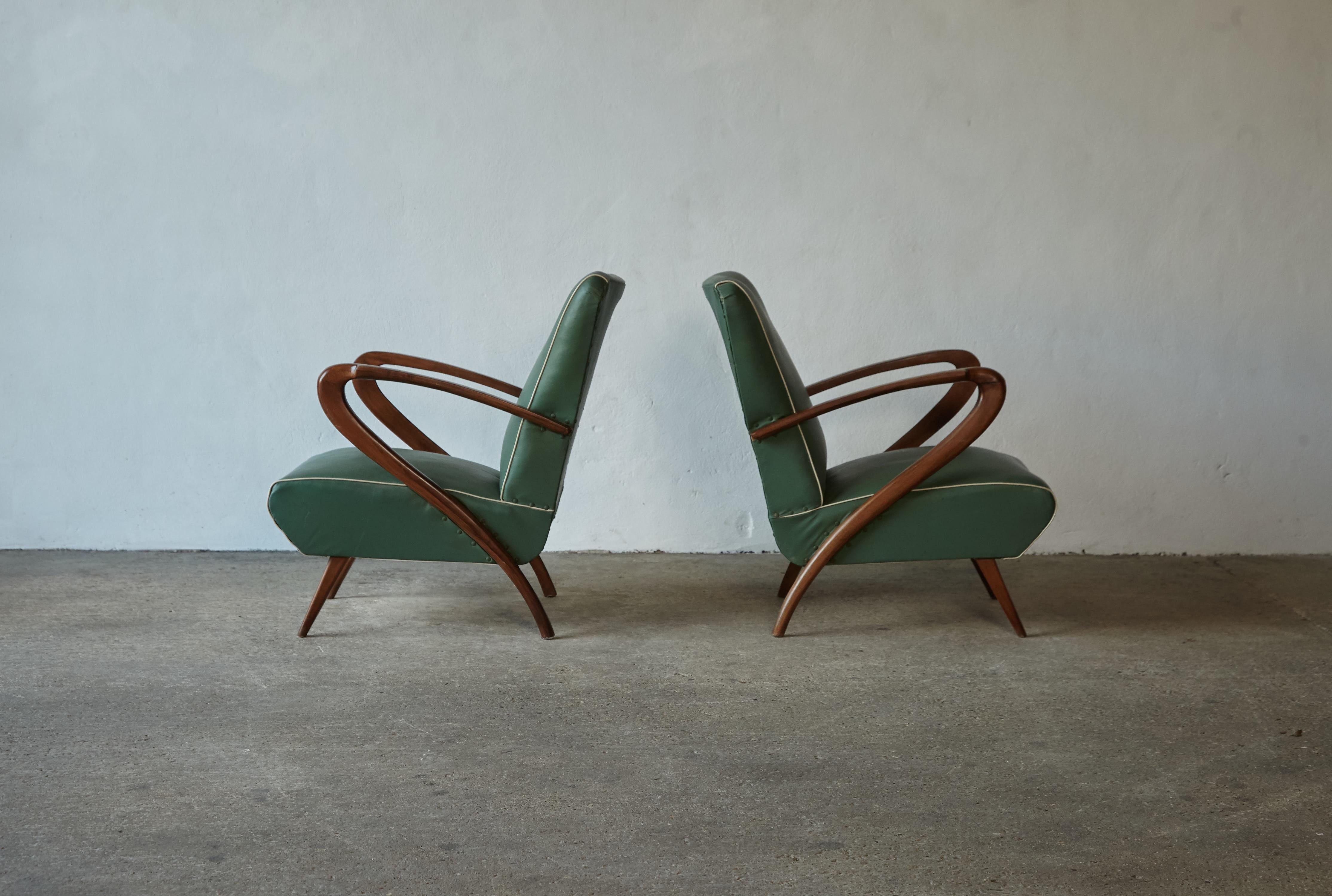 A scultptural pair of Paolo Buffa attributed lounge chairs, Italy, 1950s. The wooden frames are in original condition with minor signs of age. Original green leatherette is clean and seats function well. Please enquire about reupholstery options.