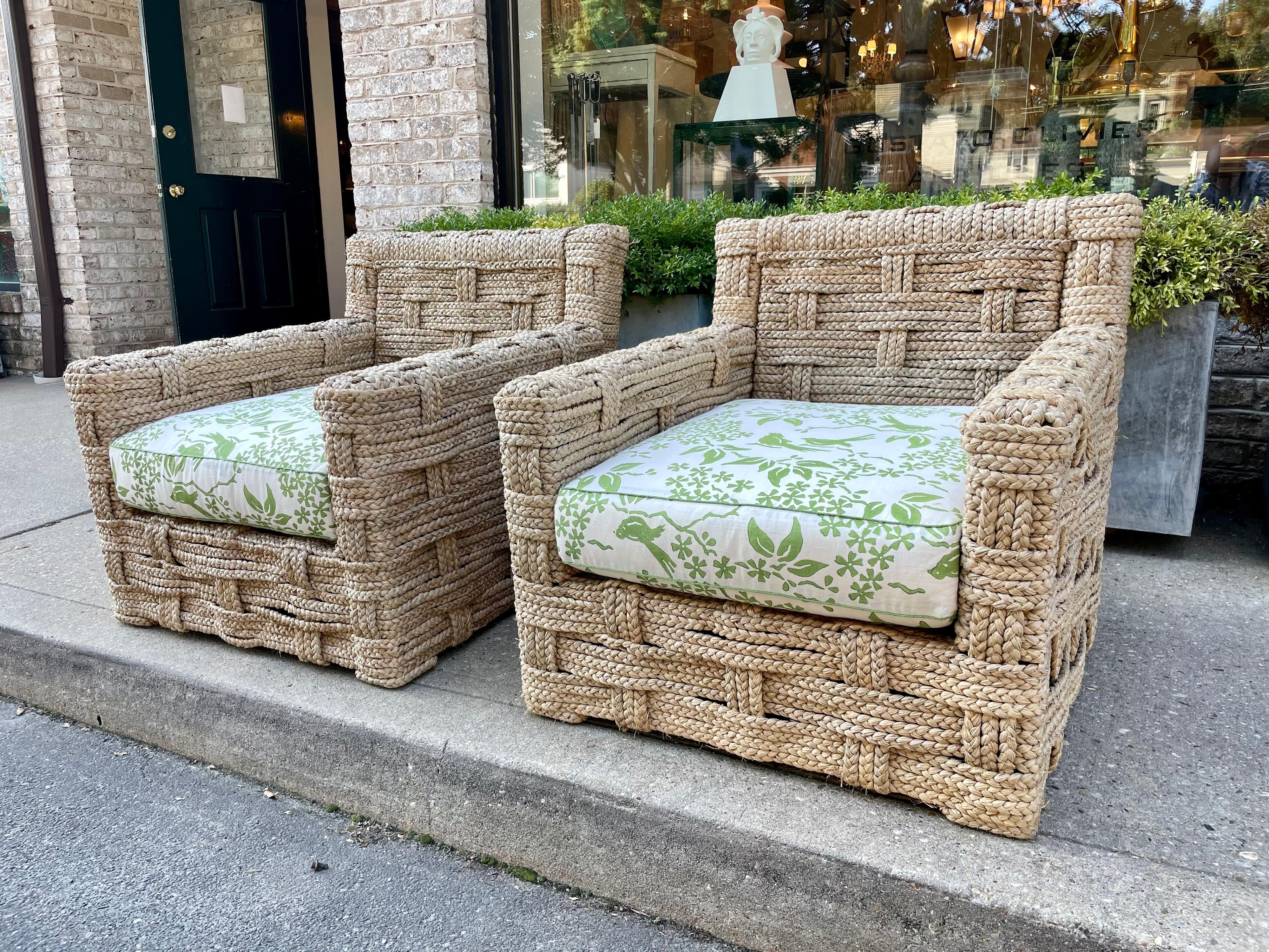 Pair of chairs, wooden structure trimmed with braided raffia in the style of Audoux-Minet in great vintage condition. Minimal wear. Upholstery is a fine linen in white and lime green foliage design. Very comfortable and sturdy.