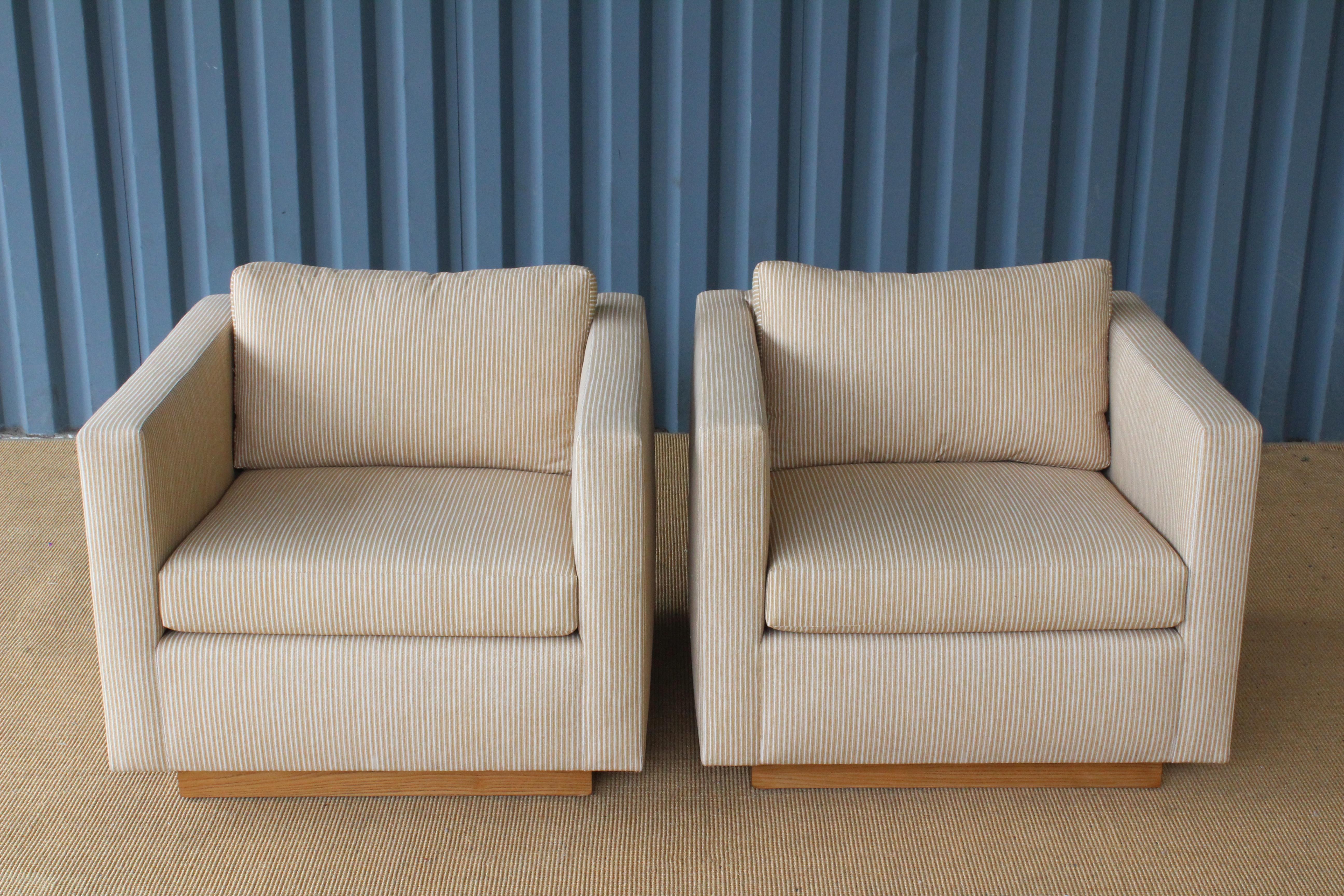 Pair of 1960s armchairs designed by Edward Axel Roffman. The pair have been reupholstered in an English cotton 'Poulton Stripe' fabric by Fermoie. They sit on walnut plinth bases that have been refinished. Price is for the pair.