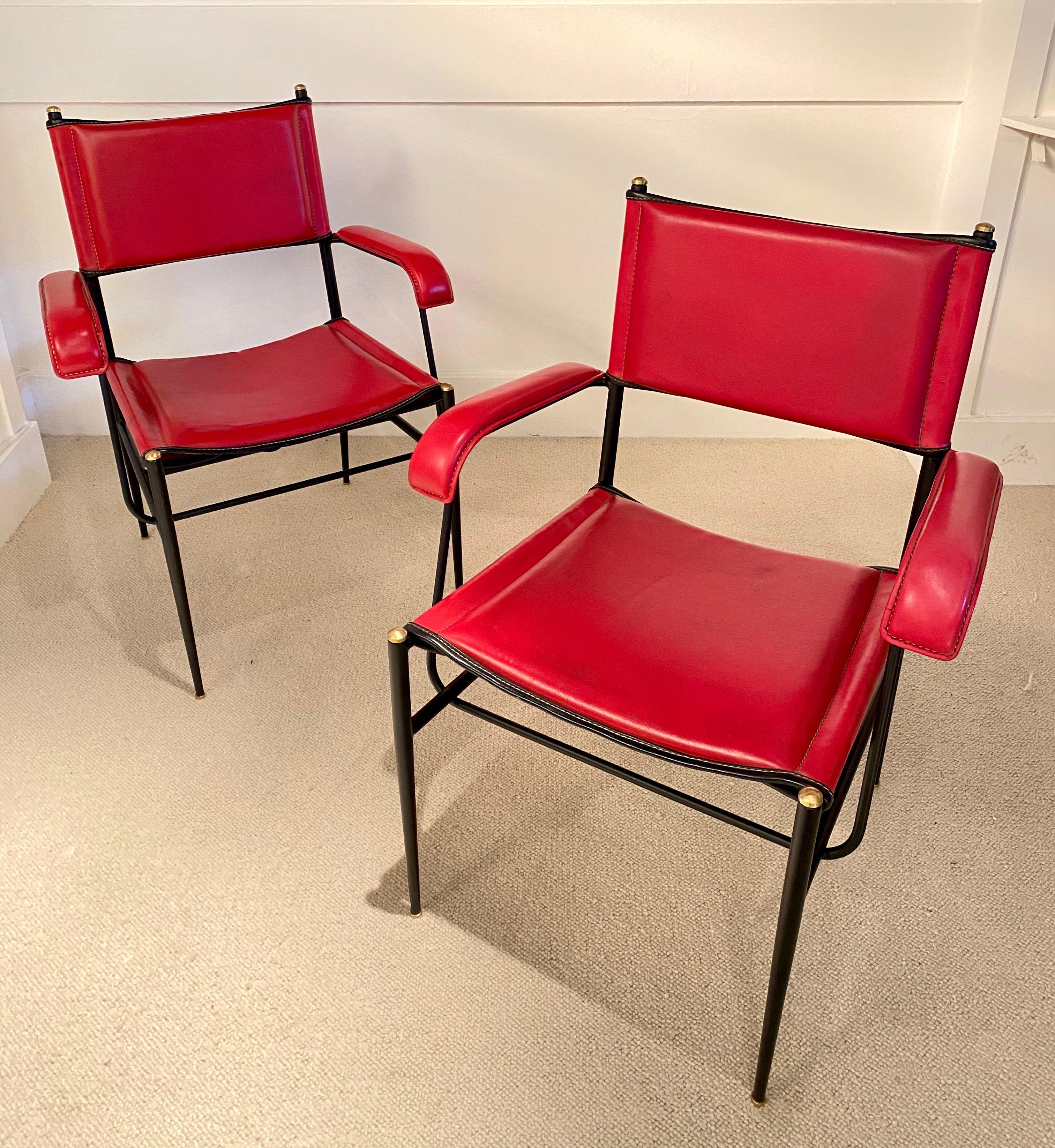 Paire de fauteuils avec structure en fer noir et détails en laiton
Cuir d'origine rouge cousu et bandes noires
Jacques Adnet, vers 1950
Excellent état.