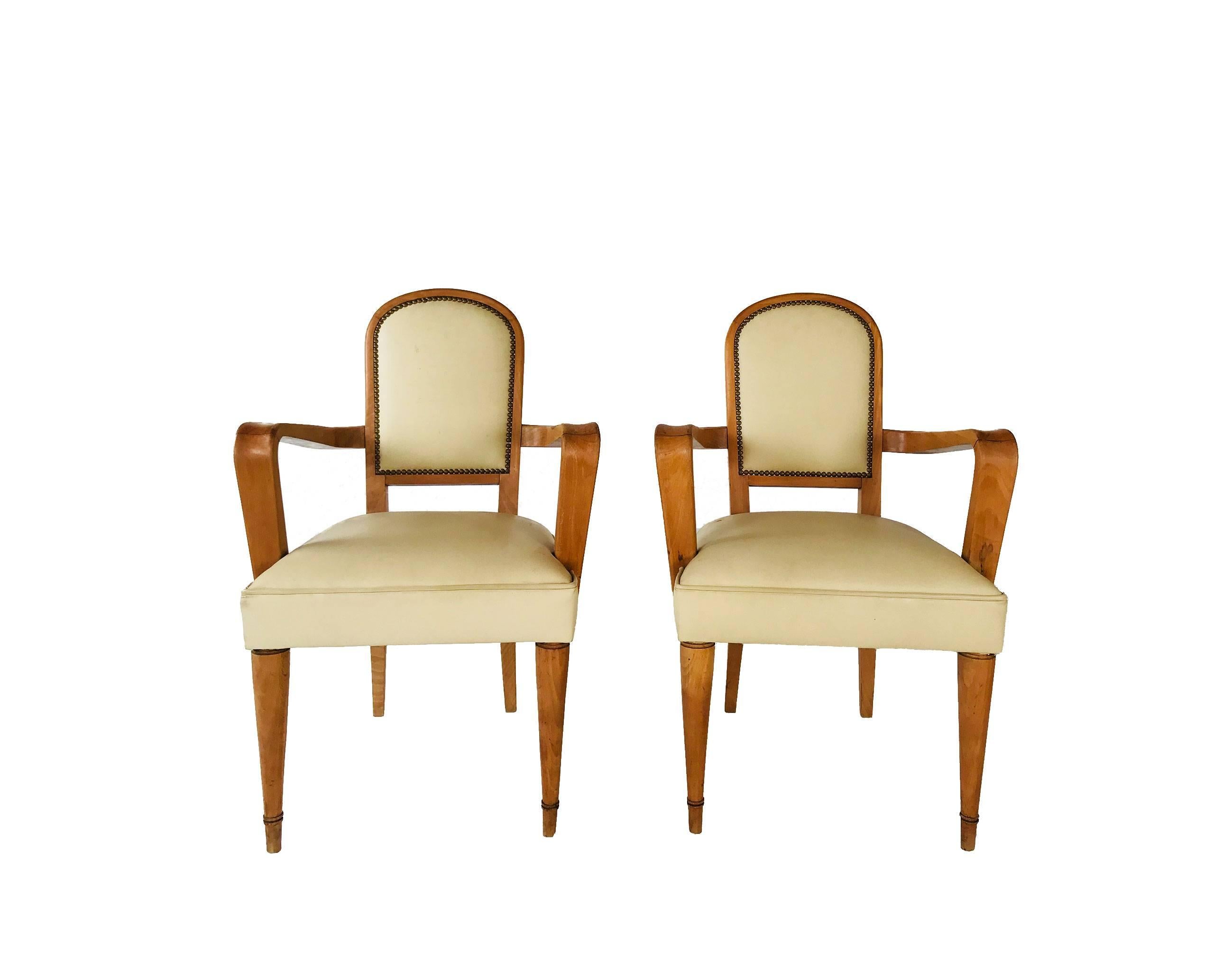 Elegant pair of French armchairs featuring beautifully curved arms, rounded back and original faux leather upholstery with brass nailhead detail. Classic French 40s with great scale and proportion.

Measures: Seat height : 18.5