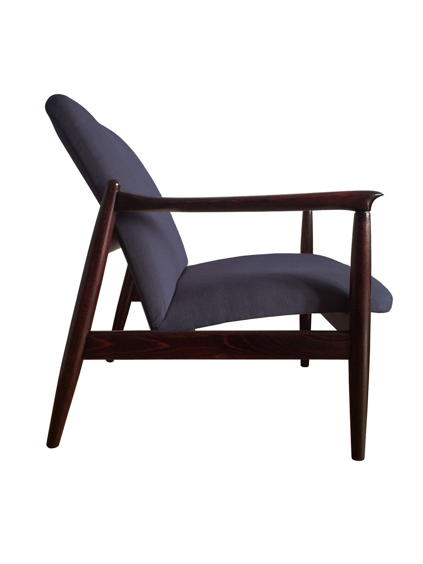 One of the icon of Polish midcentury design, model GFM-64 armchair, designed by Edmund Homa, has been manufactured by Goscinska Furniture factory in Poland in the 1960s. The structure is made of solid beechwood in a warm palisander color, finished