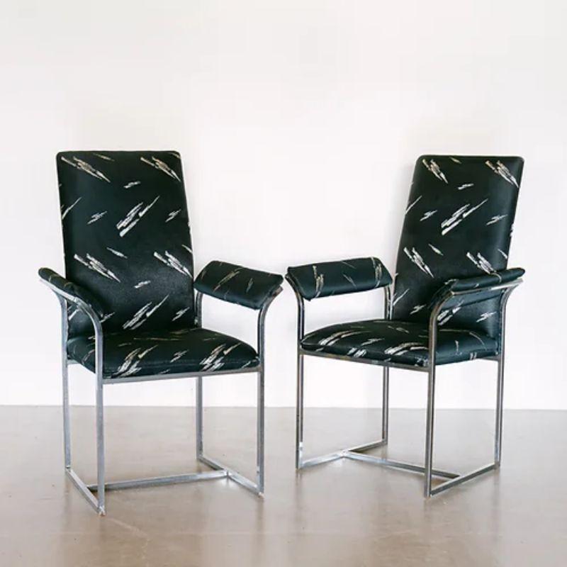 A pair of nickel framed dining chairs with arm pads upholstered in a black pattered silk, designed by Milo Baughman, 1970s.

Additional Information:
Material: Silk
Dimensions: 61 D x 65 W x 100.5 H cm
Seat Height: 45
Arm Height: 65.