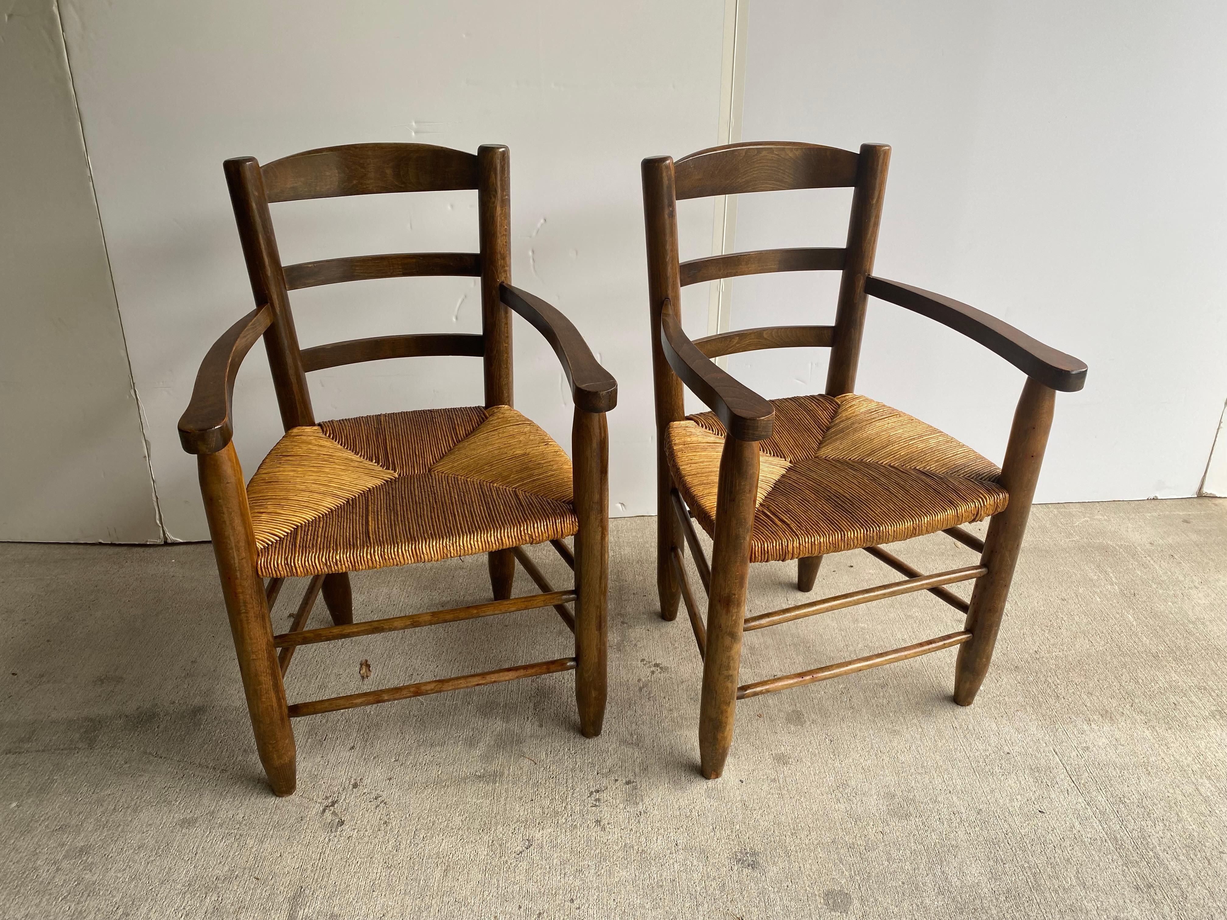 Pair of comfortable armchairs in beech or oak with woven rush seats. Great side chairs or dining chairs. In the style typical of chalet and chateau residences from mid-century France. France, 1950's.