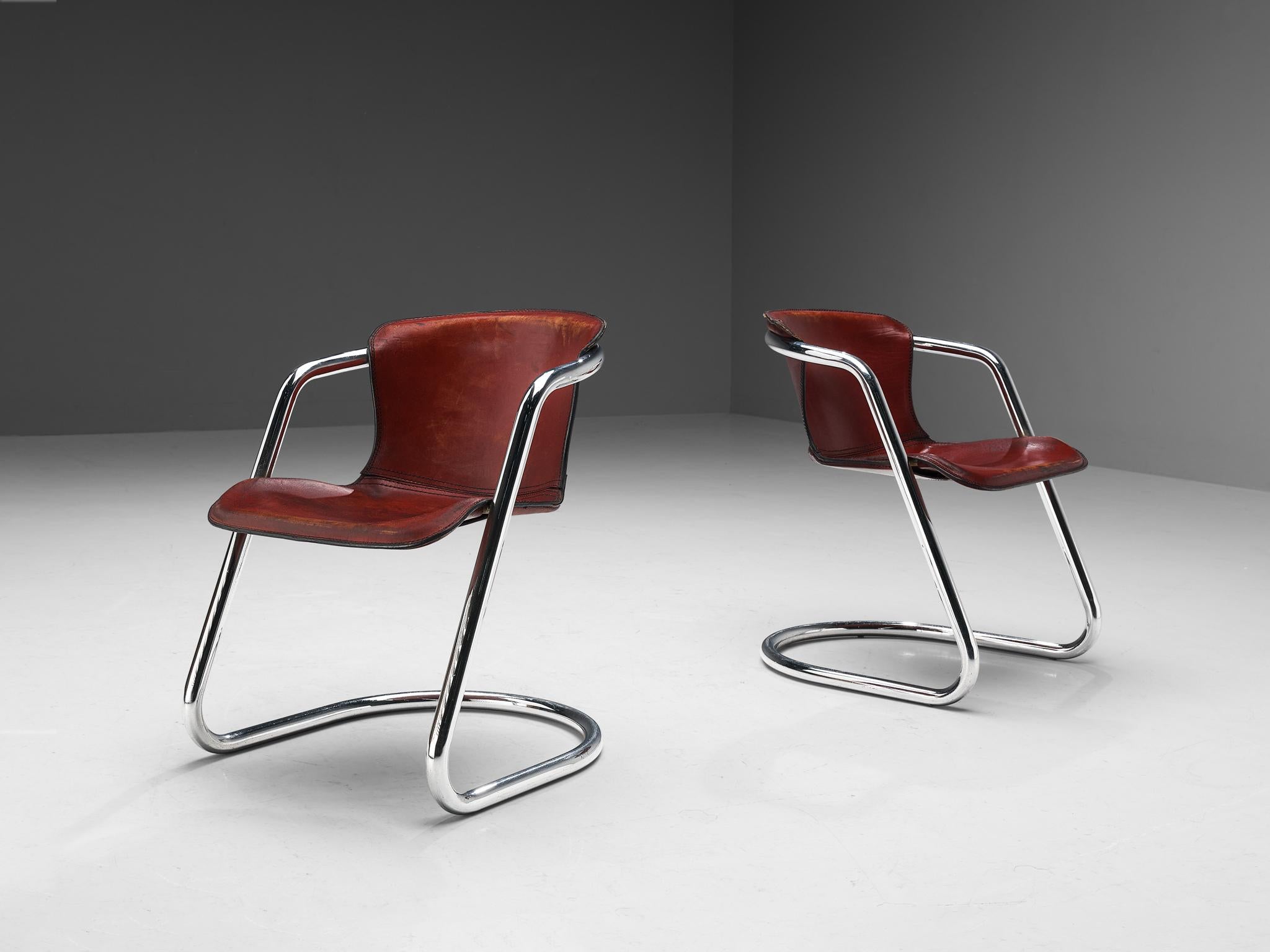 In the manner of Willy Rizzo, pair of armchairs, patinated saddle leather, chromed steel, Italy, 1970s.

This pair of armchairs is designed in the manner of Willy Rizzo and is pure and clear in its execution, giving the chair both a simple yet