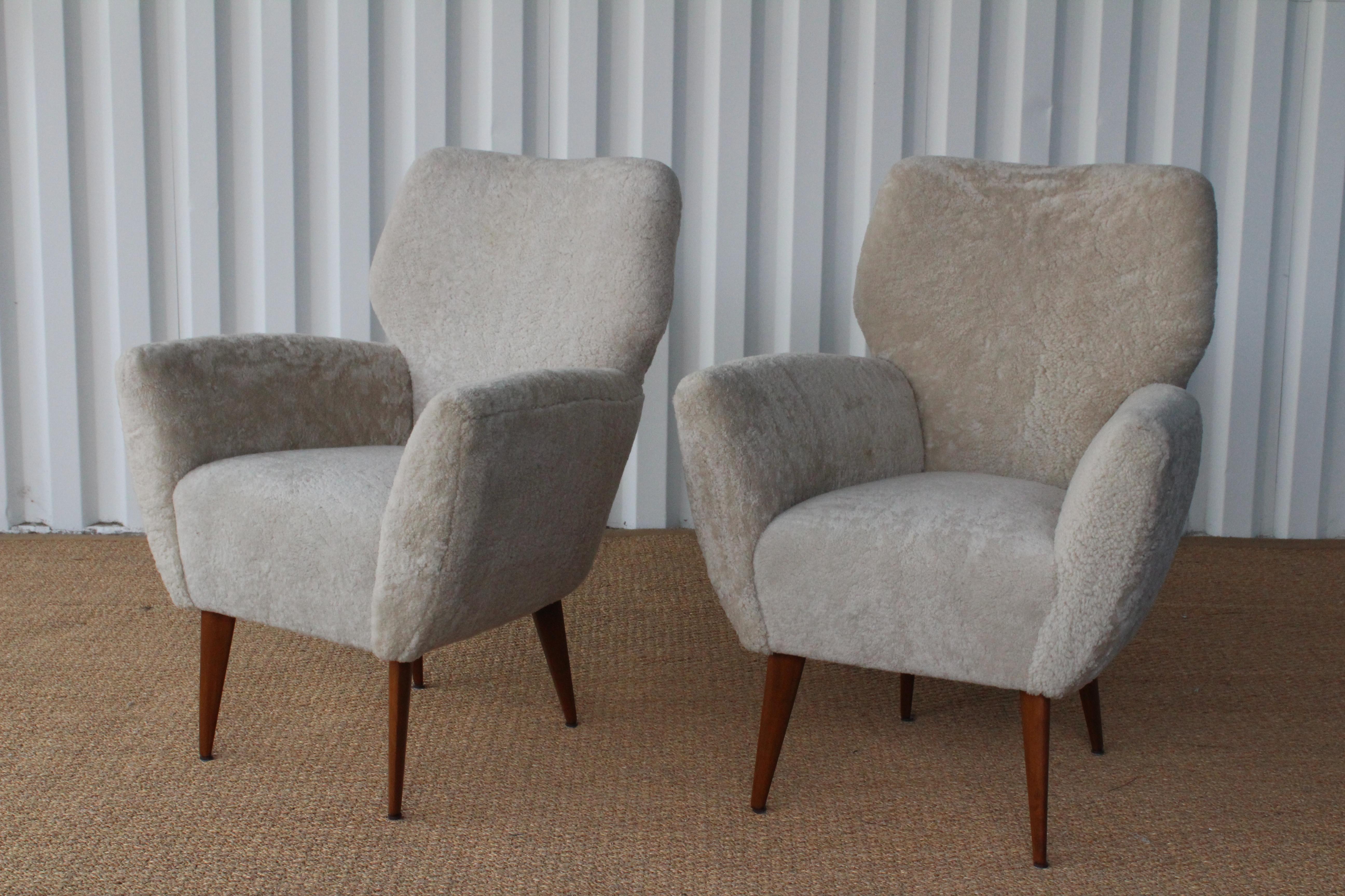 Pair of armchairs upholstered in shearling, Italy, 1950s. In the manner of Gio Ponti. Newly upholstered in a luxurious white shearling, walnut legs have been refinished. Sold as a pair.