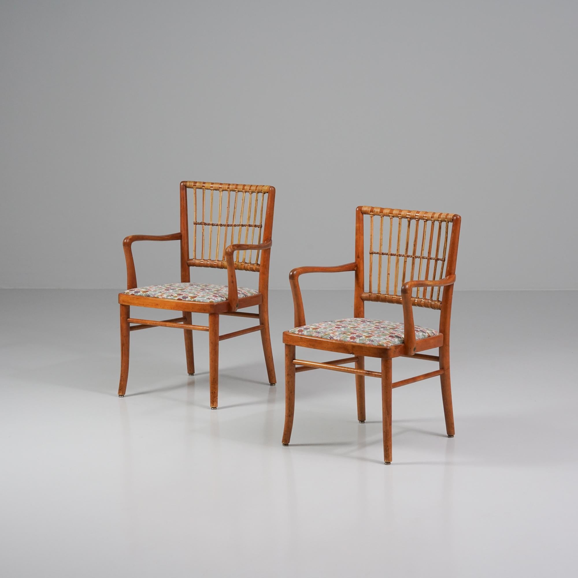 Coppia di poltrone, prodotte in Finlandia, anni '40. Struttura in betulla tinta con schienale in rattan, successivamente rivestito con tessuto floreale. Buone condizioni vintage, patina coerente con l'età e l'uso. Le poltrone sono vendute come set. 