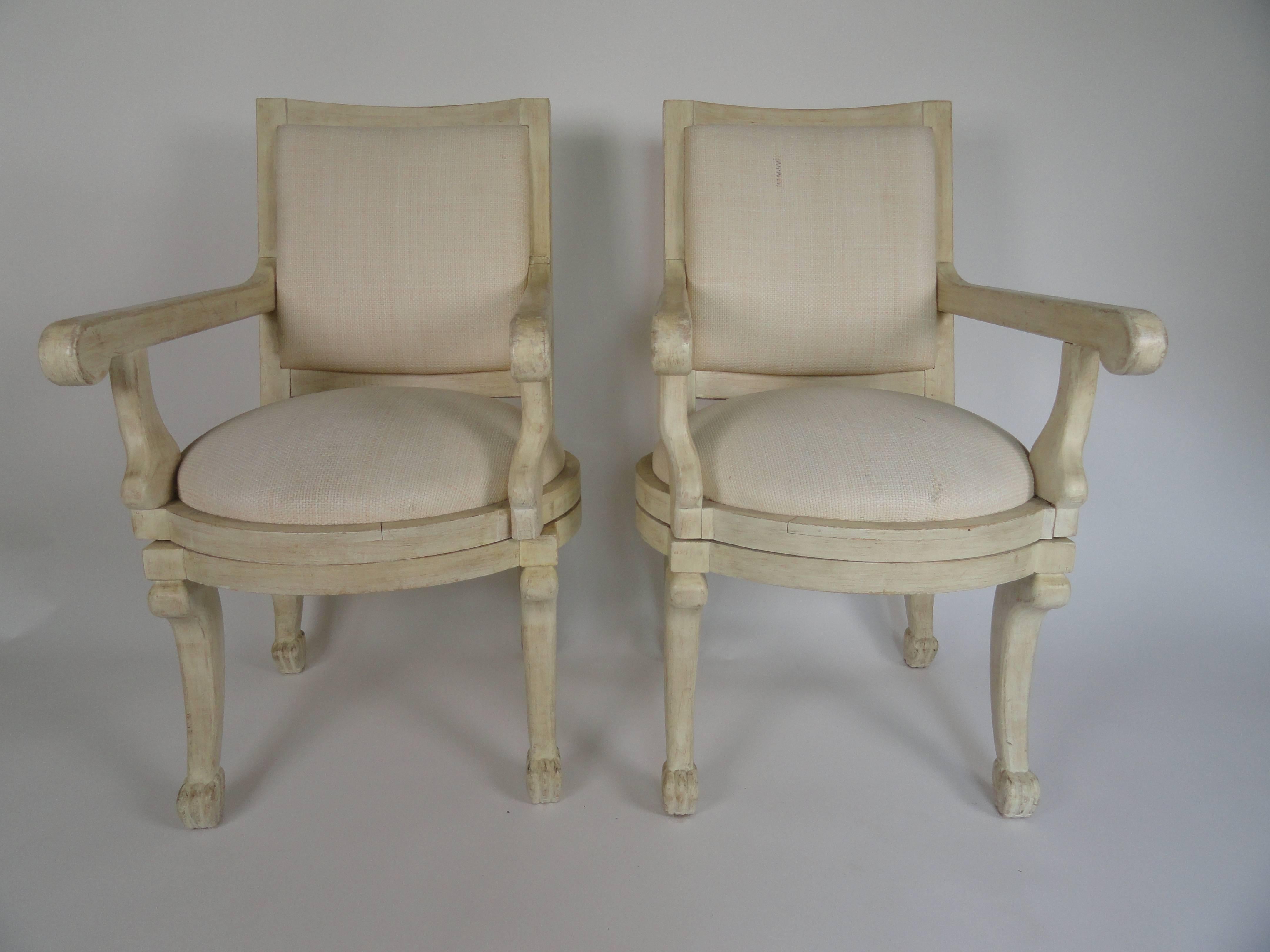 Pair of swivel armchairs in the manner of John Dickinson, sculpted wood. Finish varies. It is smooth on the back but rough, textured on the arms. Upholstered in natural raffia, which shows some natural flaws.