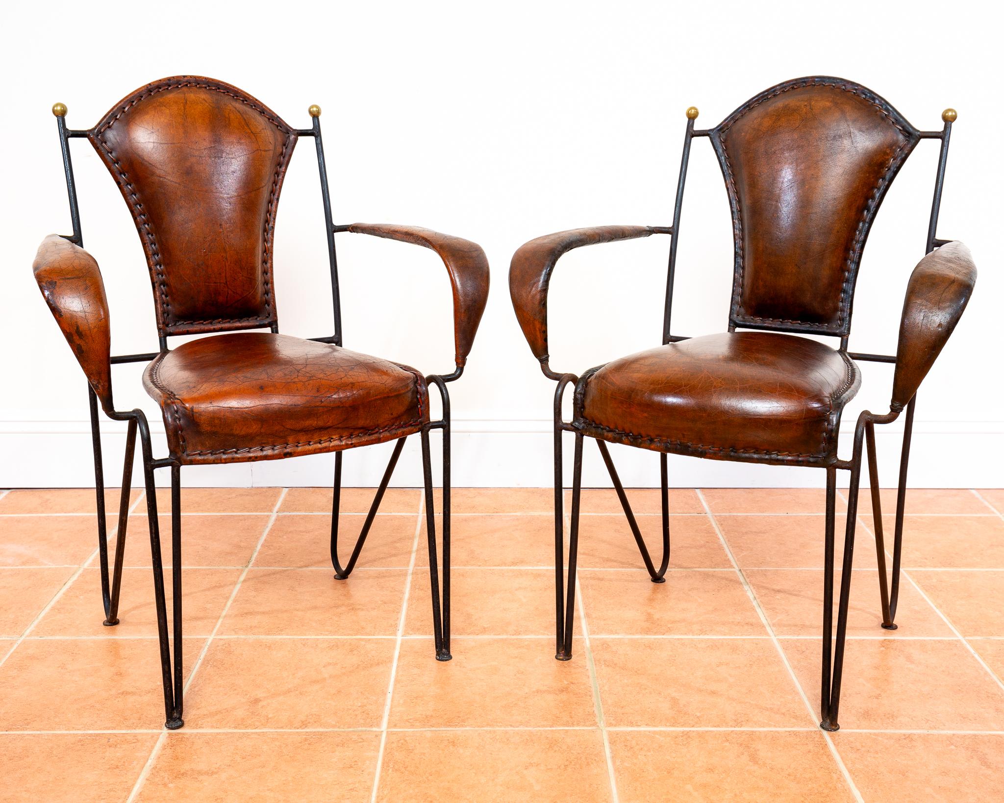 Ein fantastisches und seltenes Paar Mid Century Sessel aus Leder, Schmiedeeisen und Messing in schönem Vintage-Zustand. Die von dem französischen Modernisten Jacques Adnet entworfenen und in den 1950er Jahren in Frankreich hergestellten Sessel sind