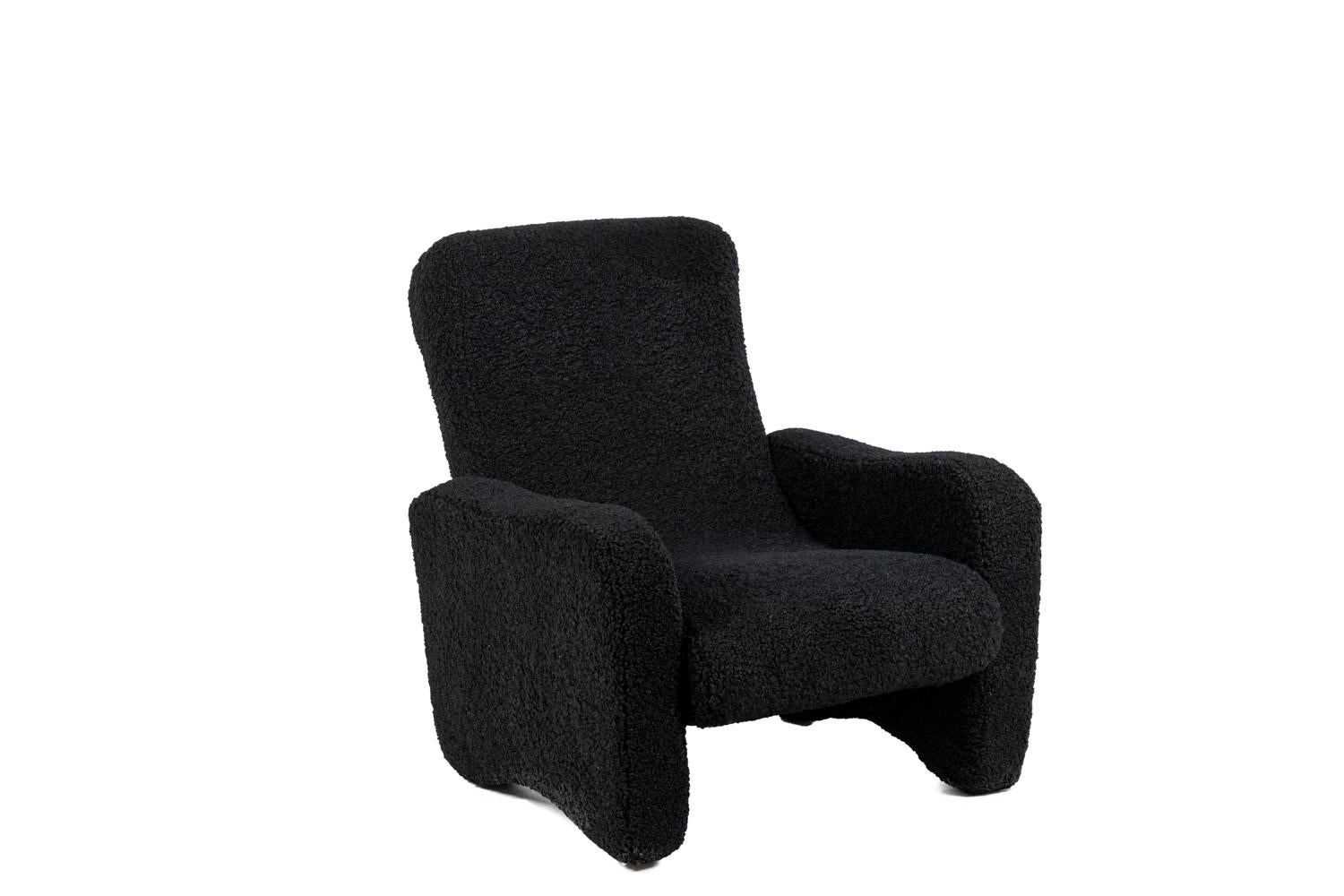 Pair of “lounge” armchairs, rectangular in shape and covered with a black loop fabric.

Work realized in the 1970s.