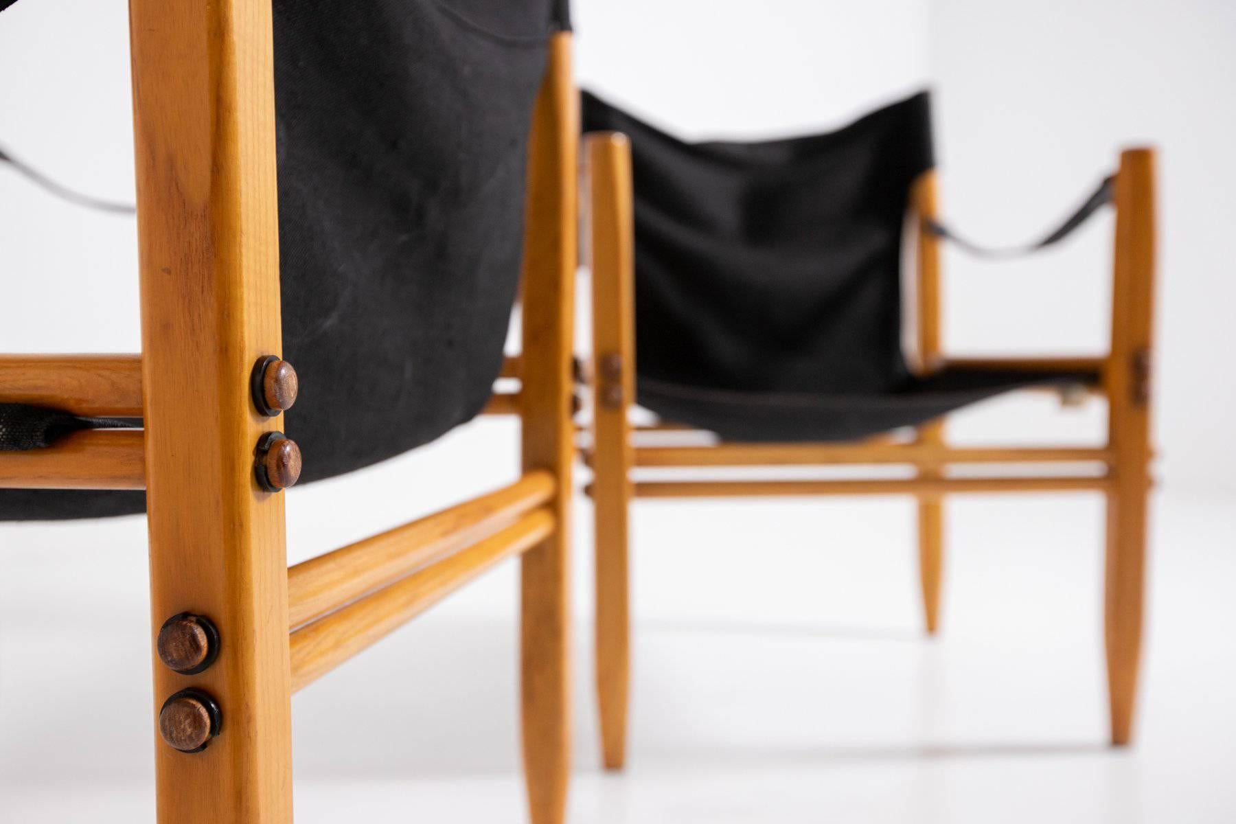 Pair of small armchairs model Oasi 85 designed by Franco Legler, produced by Zanotta, 1960. The small armchairs have a beechwood frame and black canvas covering. The peculiarity of the seat, in addition to its perfect wooden joints, is its