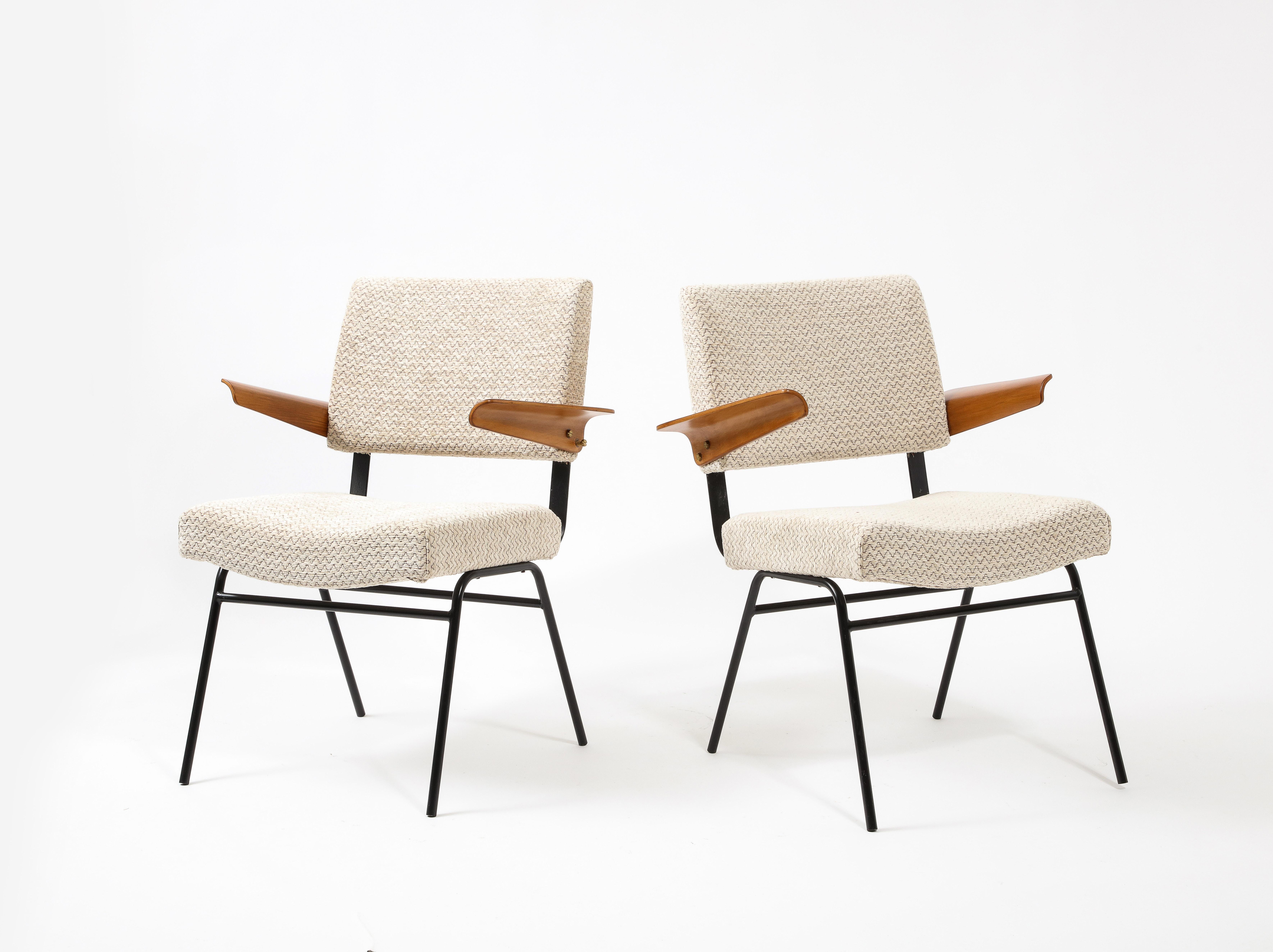Elegant pair of armchairs with bent ply arms and a flat metal connection between the seat and back that acts like a spring.
