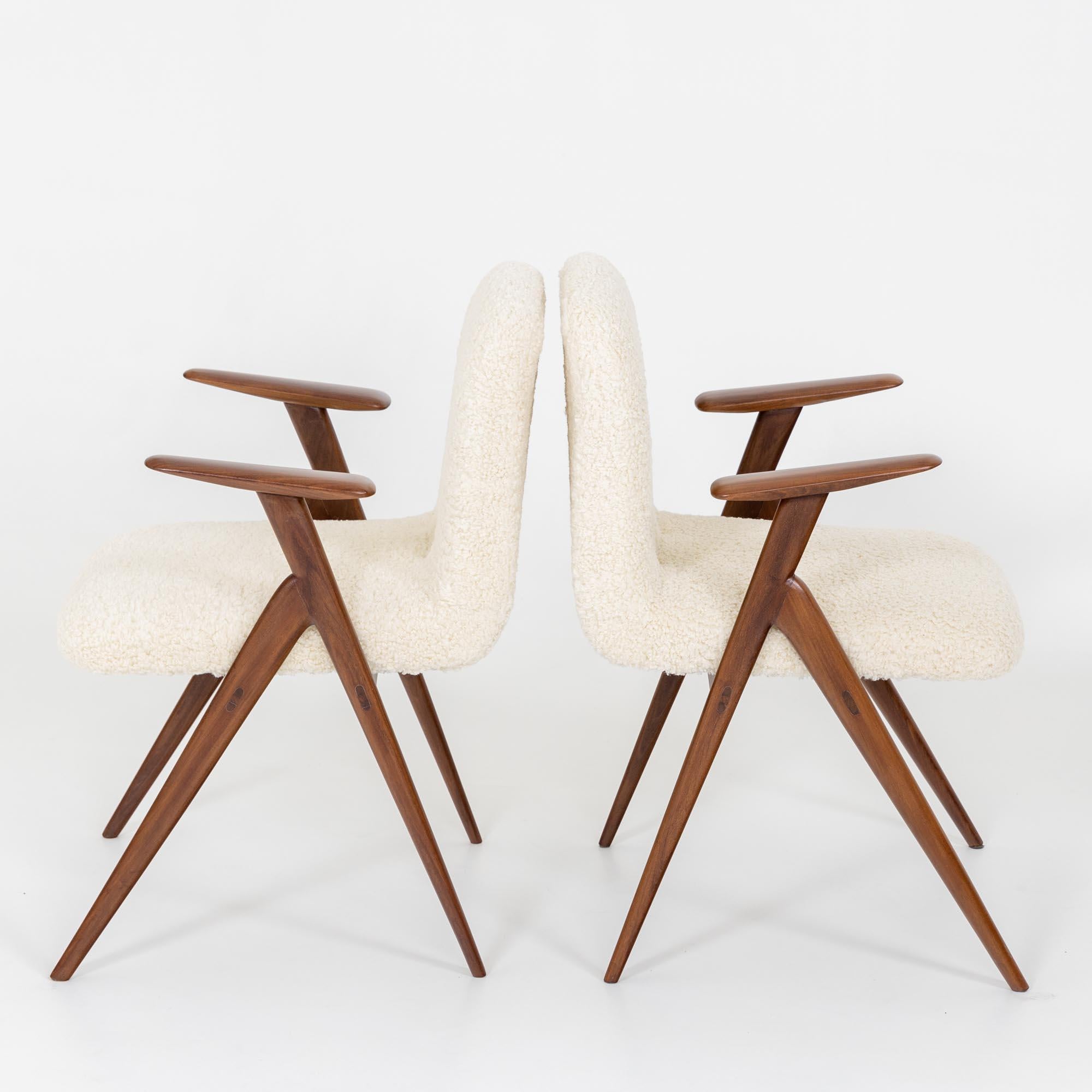 Coppia di poltrone attribuite al designer italiano Luigi Vietti (1903-1998). Le sedie poggiano su una struttura in legno liscio con gambe e braccioli affusolati. La seduta e lo schienale sono stati rivestiti con un morbido bouclé in bianco crema.