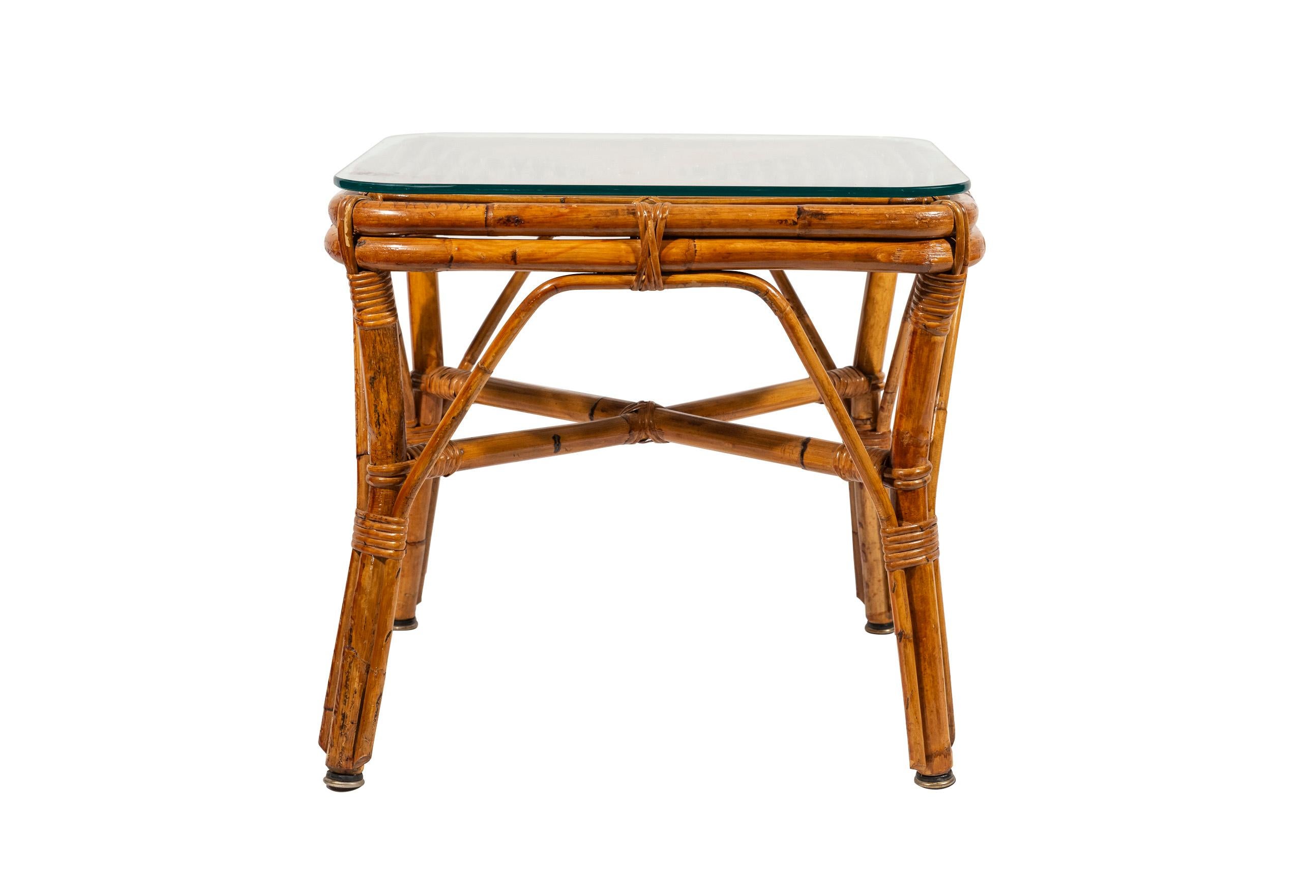 Paire de fauteuils avec table basse, 
Bambou et rotin, 
La table a un plateau carré en verre, 
circa 1970, France.

Fauteuil : hauteur 85 cm, hauteur d'assise 33 cm, largeur 64 cm, profondeur 68 cm.
Table basse : hauteur 60 cm, largeur 63 cm,