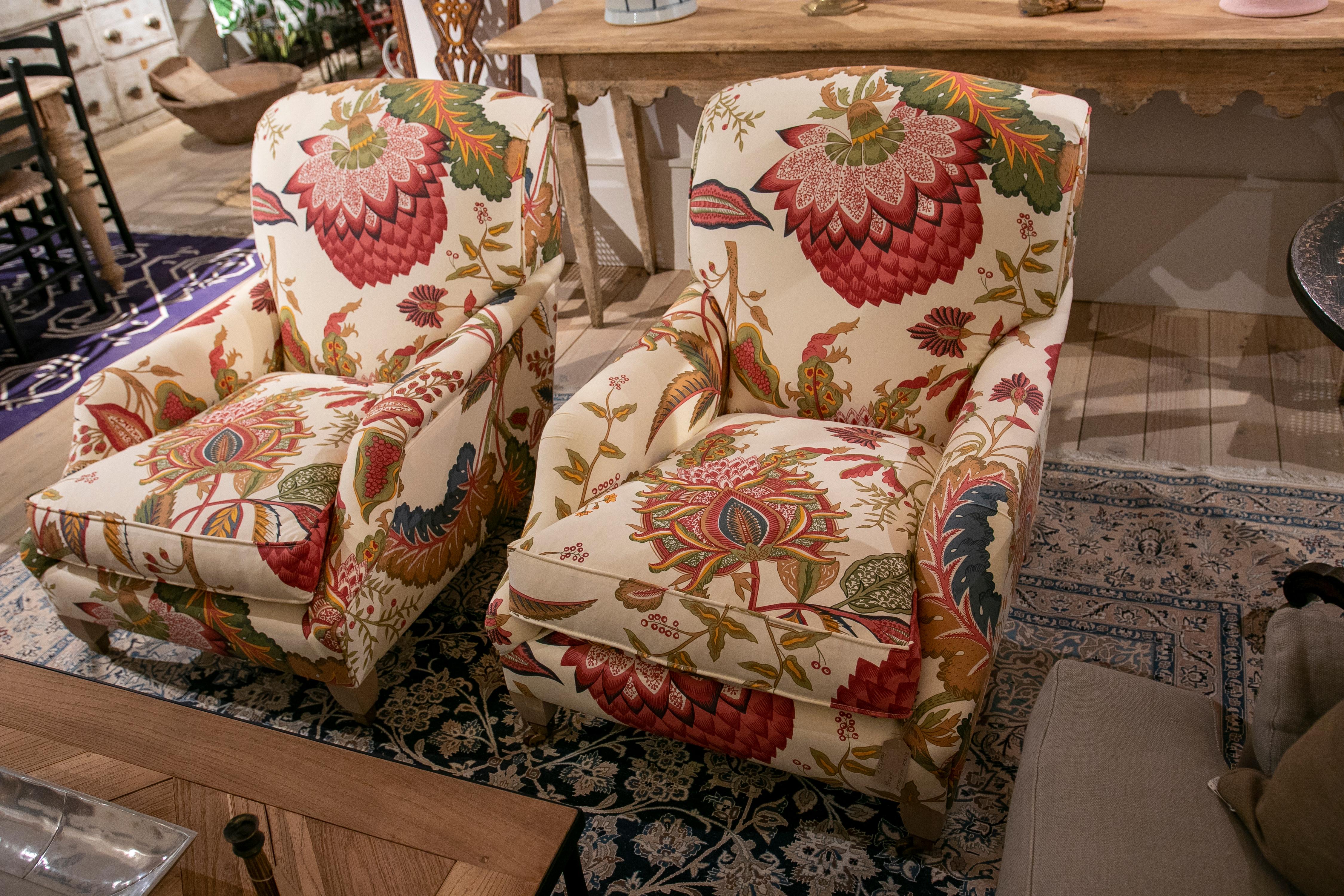 Pair of armchairs with wooden structure and Gaston&Daniela's upholstery. As unique details, the armchairs have small wheels at the end of the legs like the old classics and the fabric has an exotic design in warm colors.
