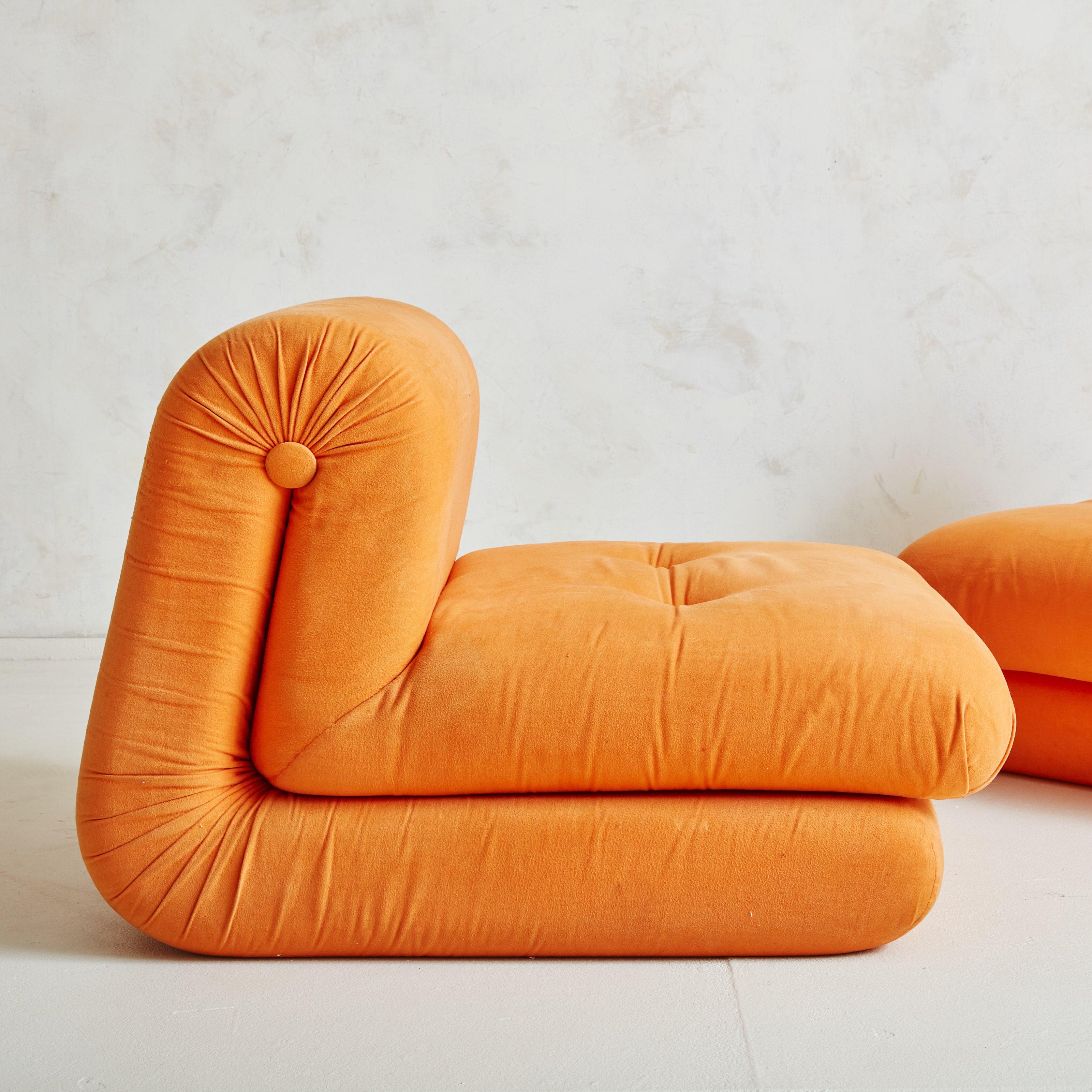 Pair of 1970s Italian lounge chairs featuring sculptural curved profiles with plush seats and angled backs. The modular, armless silhouettes can be placed together as a loveseat or used individually as lounge chairs. These chairs include the