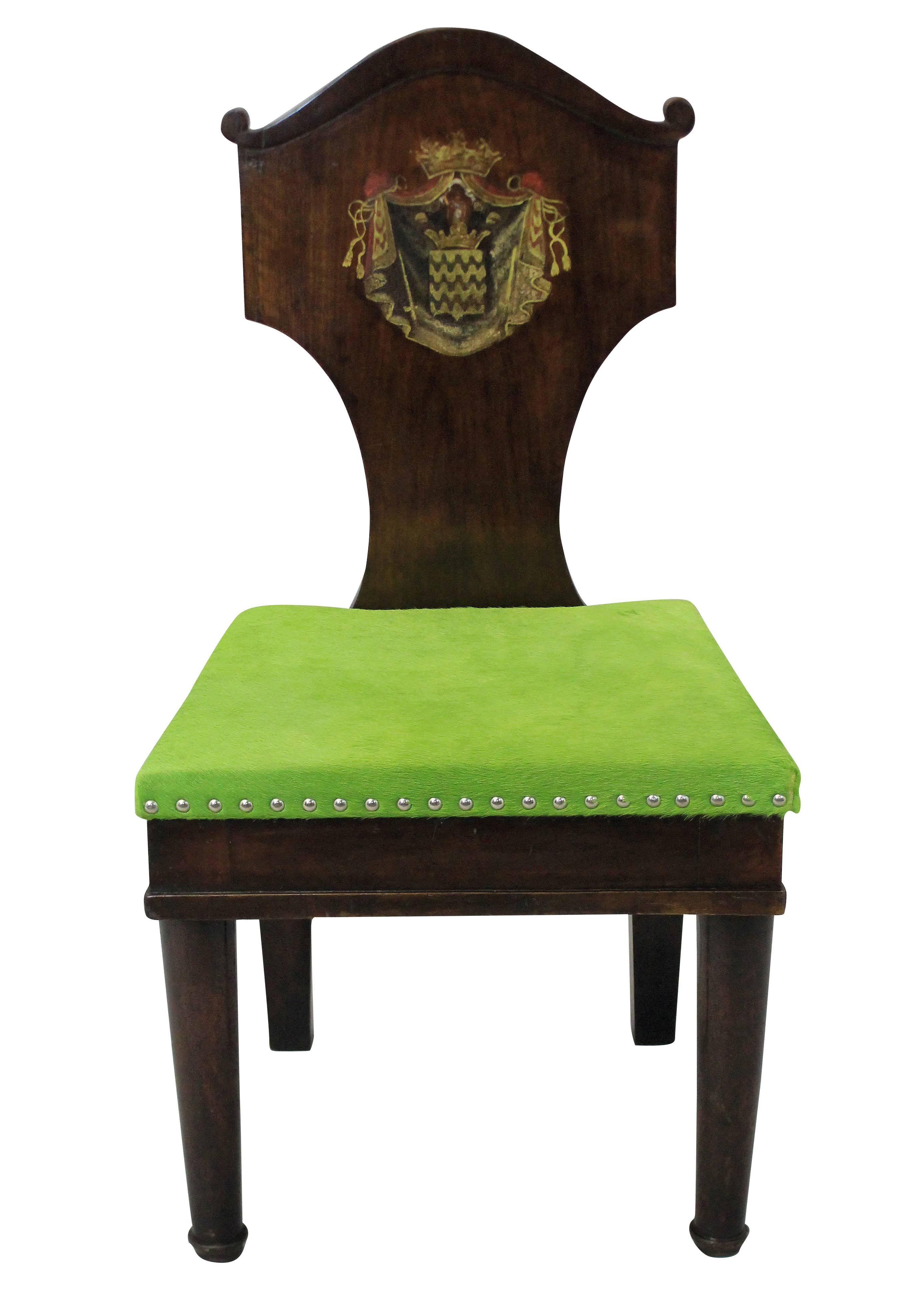 A pair of large scale 18th century hall chairs in the manner of Thomas Hope. In mahogany with hand painted armorial crests. Newly upholstered in lime green cow hide.

   