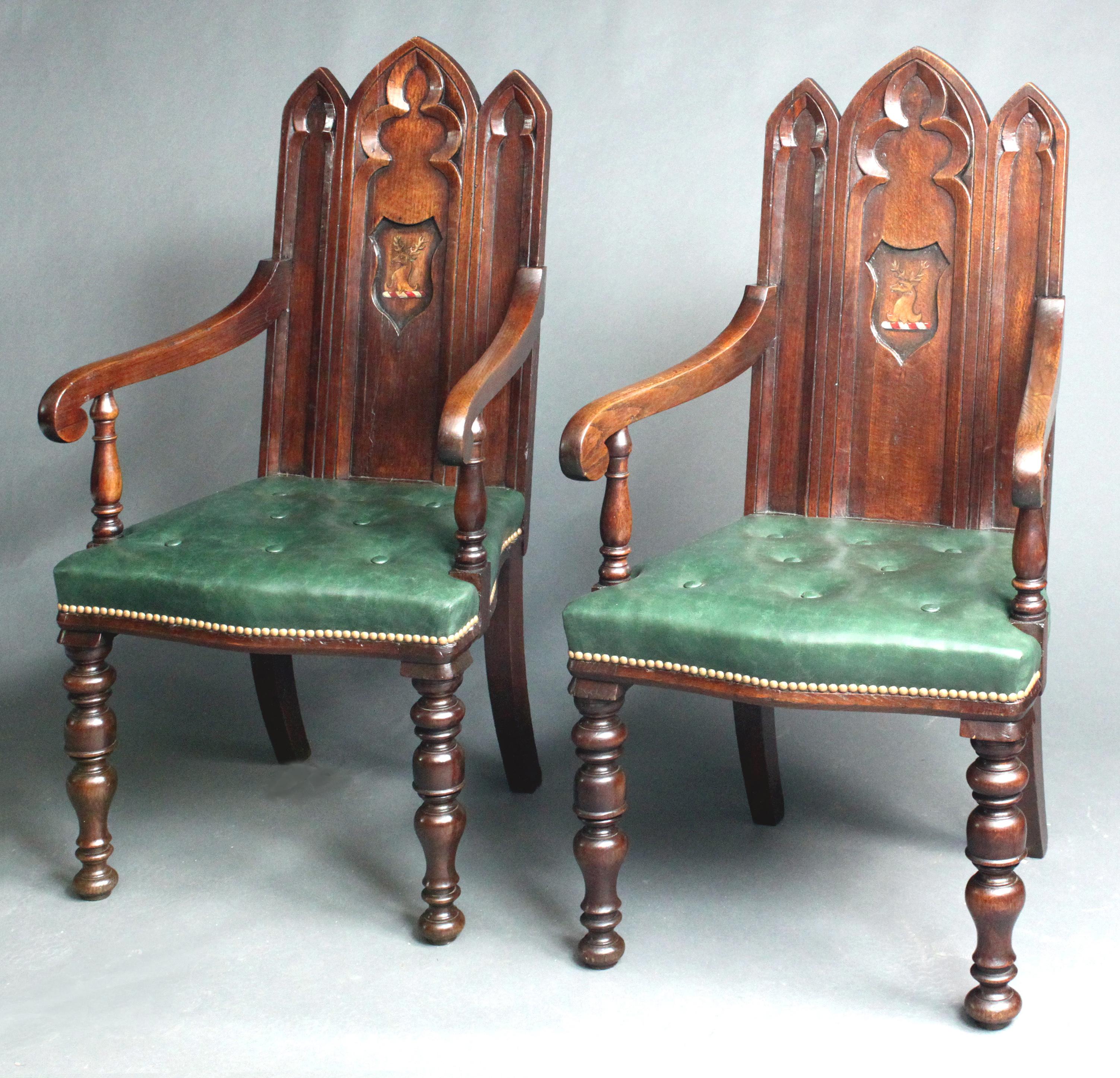 A pair of Victorian gothic oak hall chairs with arms; well turned front legs and green leather buttoned seats.
There was evidence of paint in the centre reserves, no doubt a crest or armorial which had been removed, so we commissioned a local artist