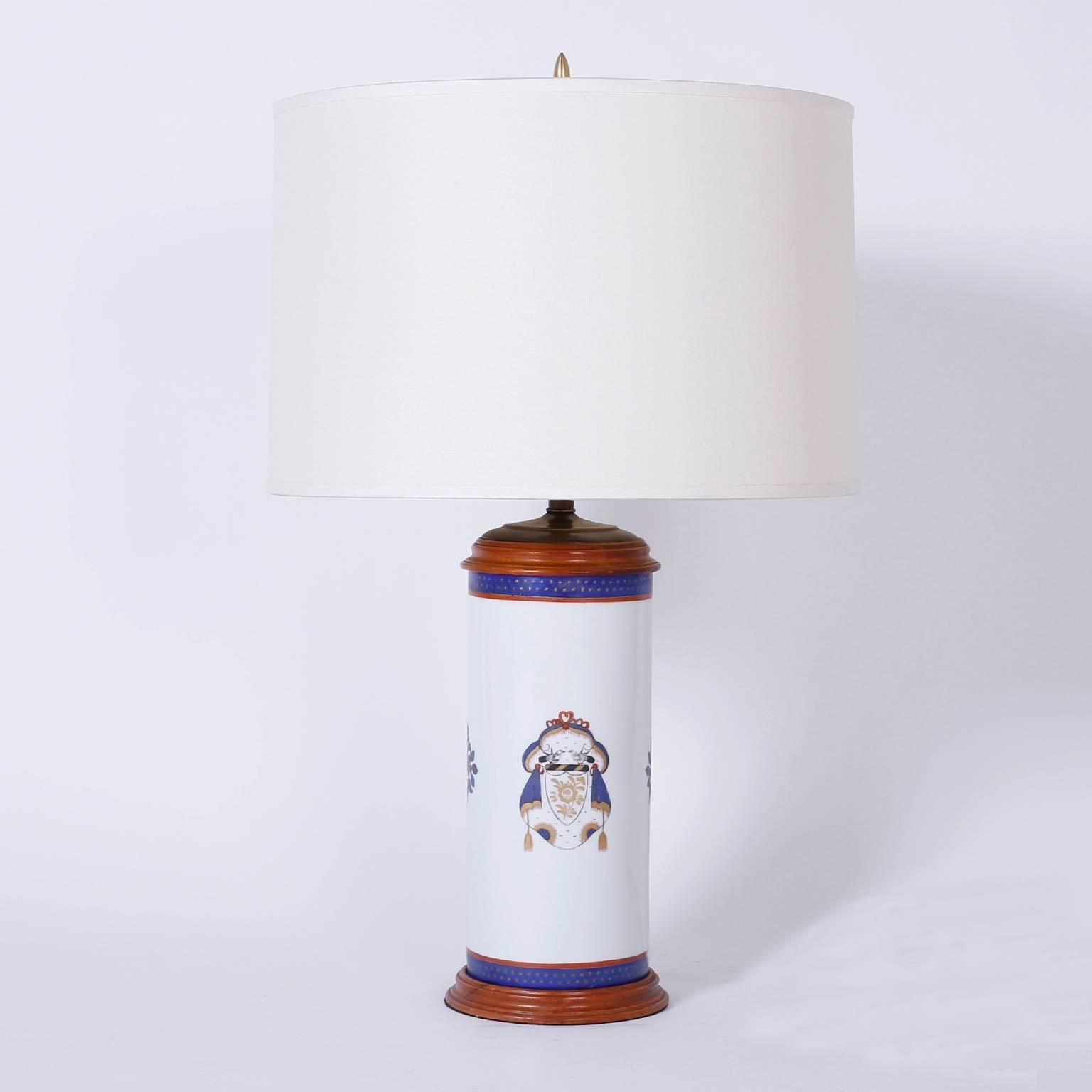Handsome pair of porcelain table lamps hand-painted with Heraldic coats of arms and floral medallions on a white background.