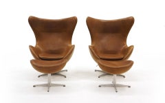 Pair Arne Jacobsen Egg Chairs with Ottomans, Cognac Leather. Price is for all.