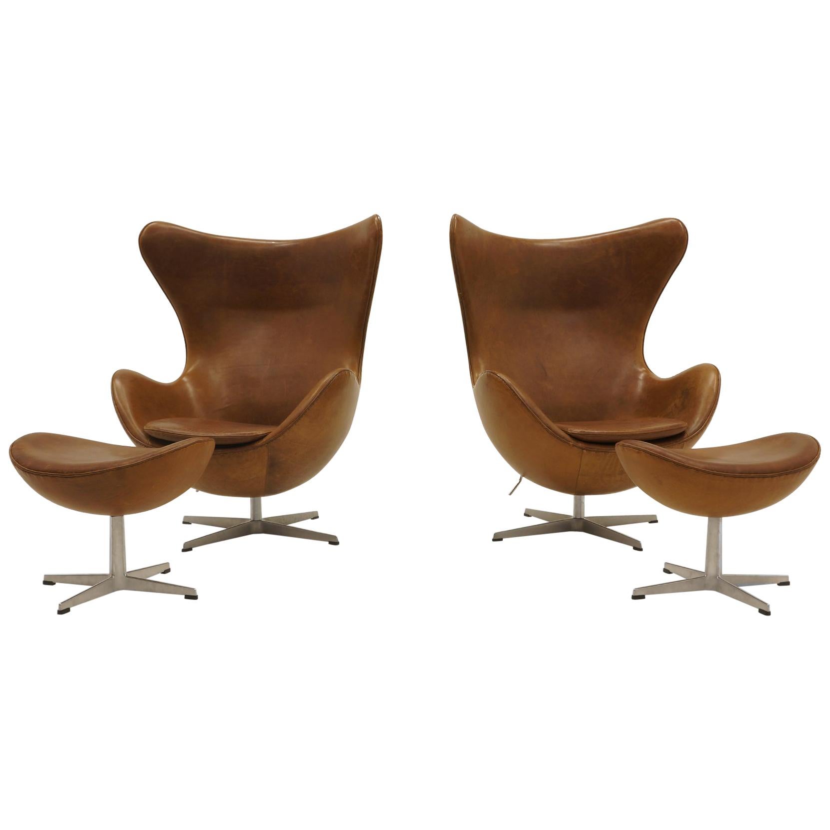 Pair Arne Jacobsen Egg Chairs with Ottomans, Cognac Leather. Price is for all.