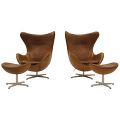 Pair Arne Jacobsen Egg Chairs with Ottomans, Cognac Leather. Price is for all.