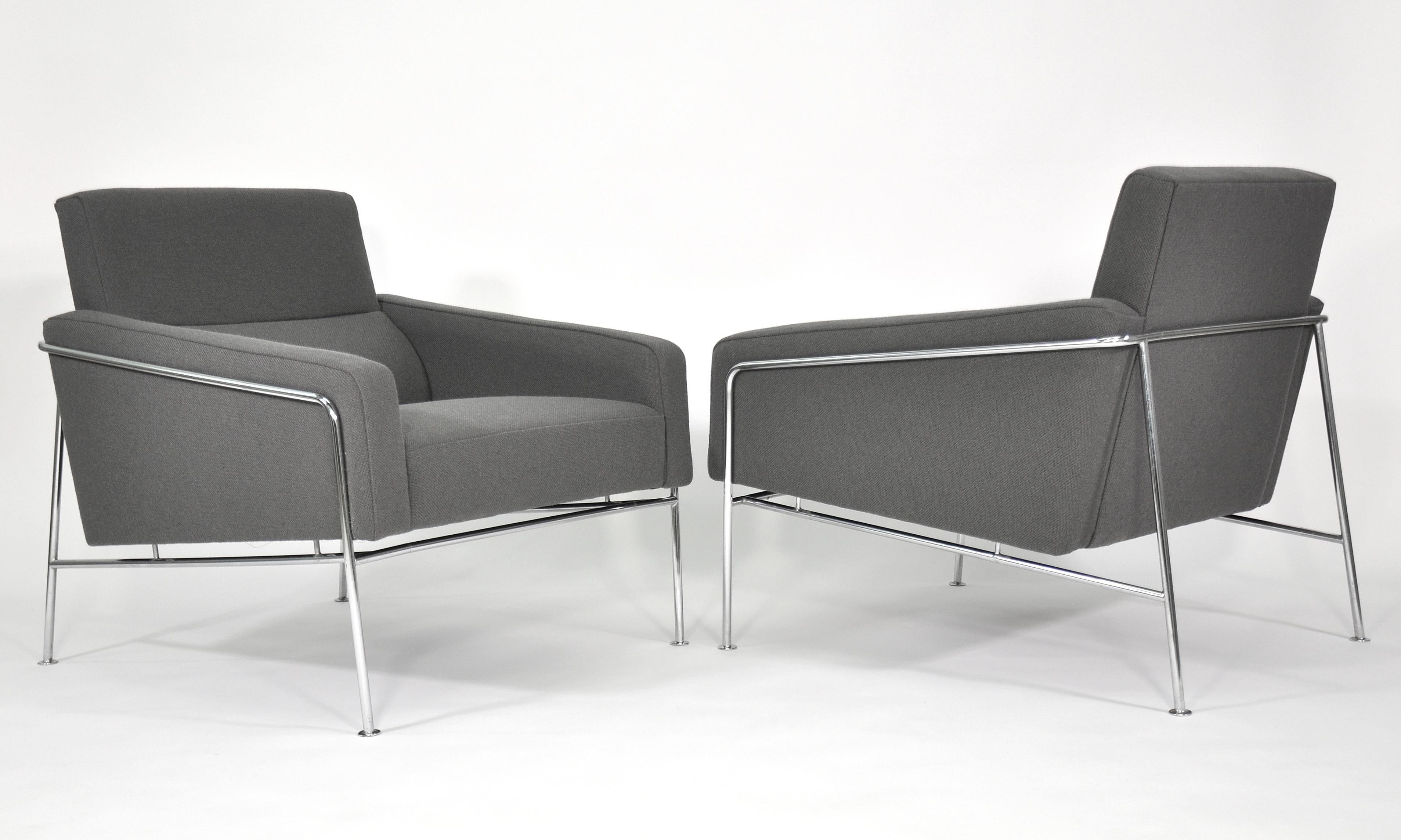 Iconic pair of vintage midcentury armchairs from the 3300 series designed by Arne Jacobsen in 1956 and manufactured in Denmark by Fritz Hansen. The bucket style seats appear to float within a thin and clean-lined chrome frame. The chairs feature a