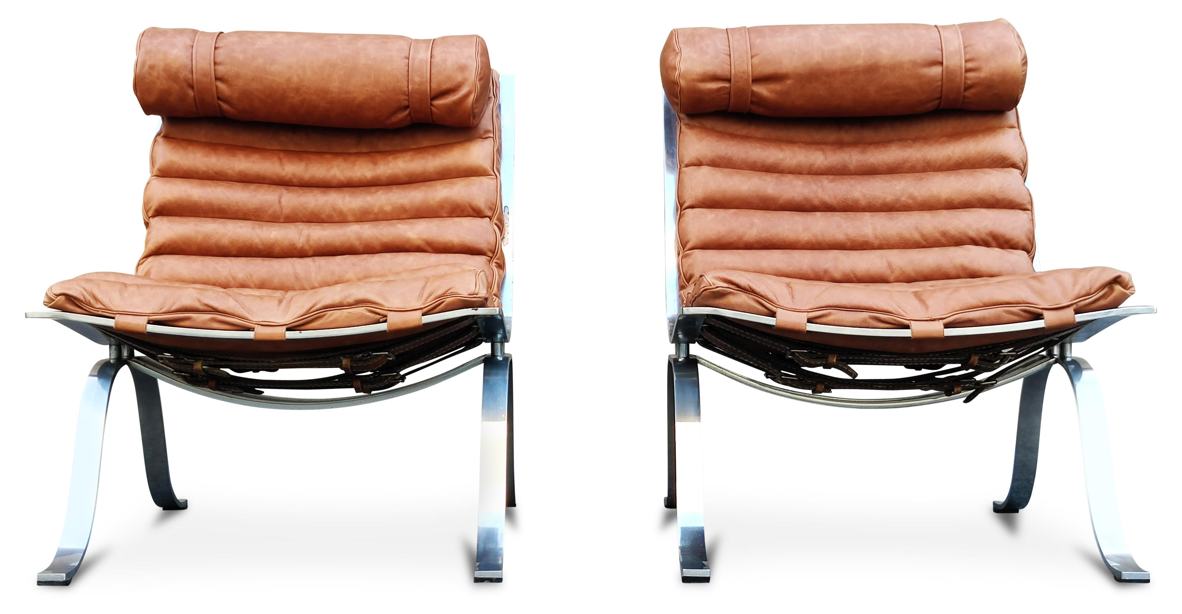 This beautiful pair of lounge chairs were designed in the 1960s by Arne Norell for Norell Moebel. The frames are made of two curves of chrome-plated steel, and the single cushions have been newly reupholstered in channel-stitched, cognac-colored