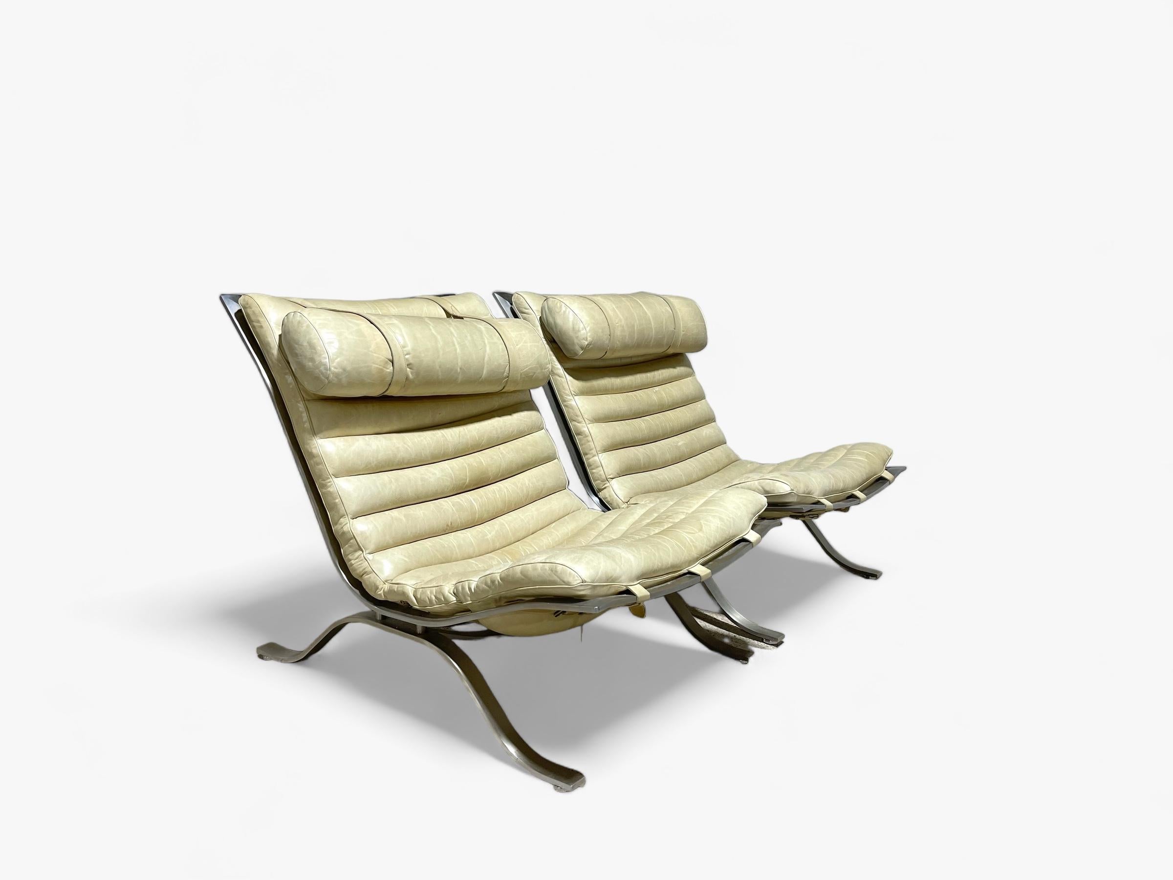 Paire de spectaculaires chaises longues Arne Norells en cuir ivoire patiné. Sans doute l'une des chaises de salon les plus recherchées et les plus collectionnées de la période The Modern Scandinavian. 

Les chaises ont été fabriquées par Norell
