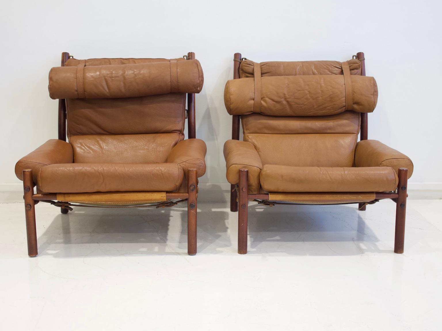 Arne Norell easy chairs, model Inca, produced in Sweden. Frame made of stained hardwood. Seat and back cushions upholstered in brown leather. Loose neck cushion with leather straps. Labeled on the bottom.
Slight fading and some stains on upholstery