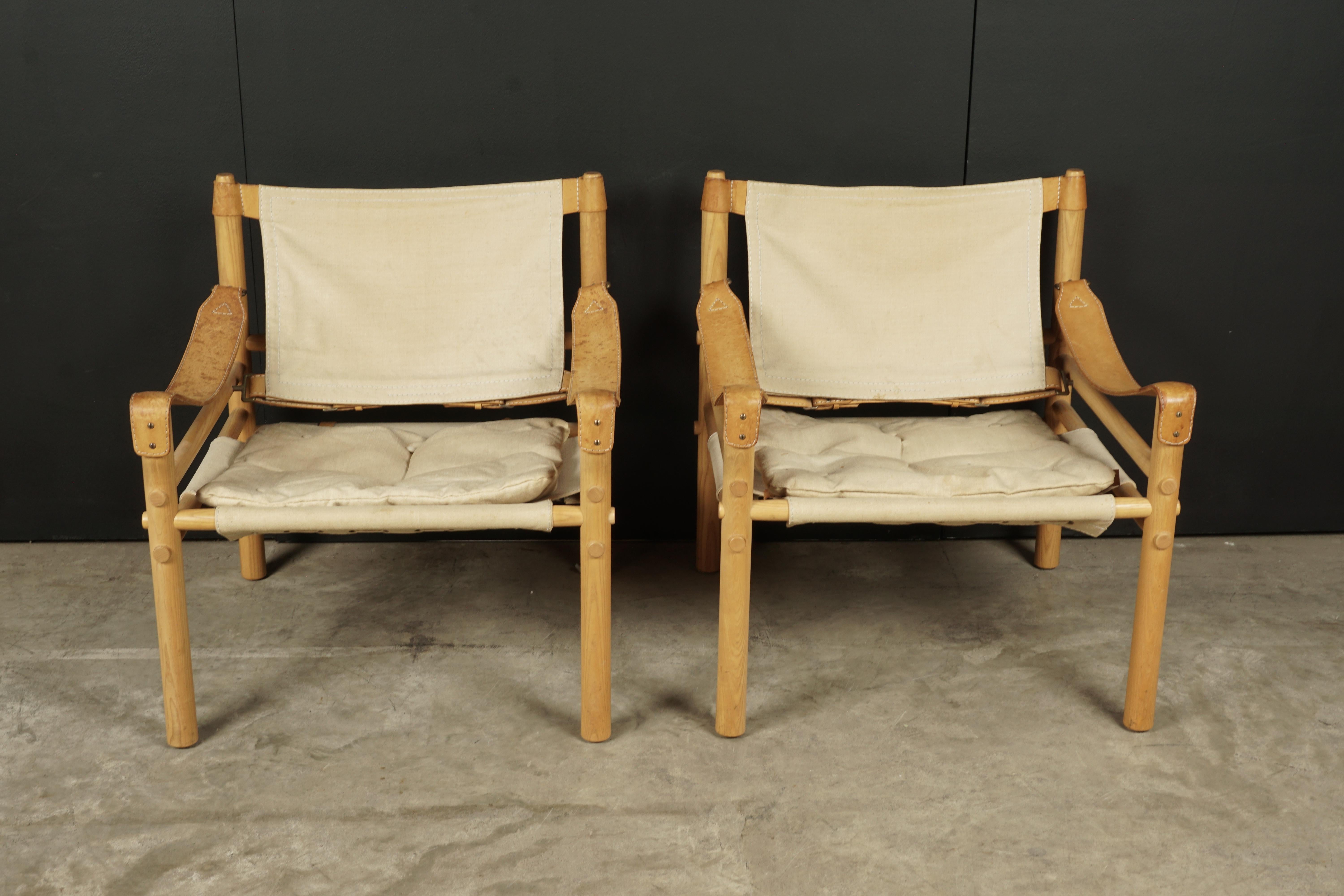 Pair of Arne Norell lounge chairs, Model Sirocco, Sweden, circa 1970. Original canvas upholstery stretched on a solid oak frame. Produced by Arne Norell AB, Aneby Sweden.