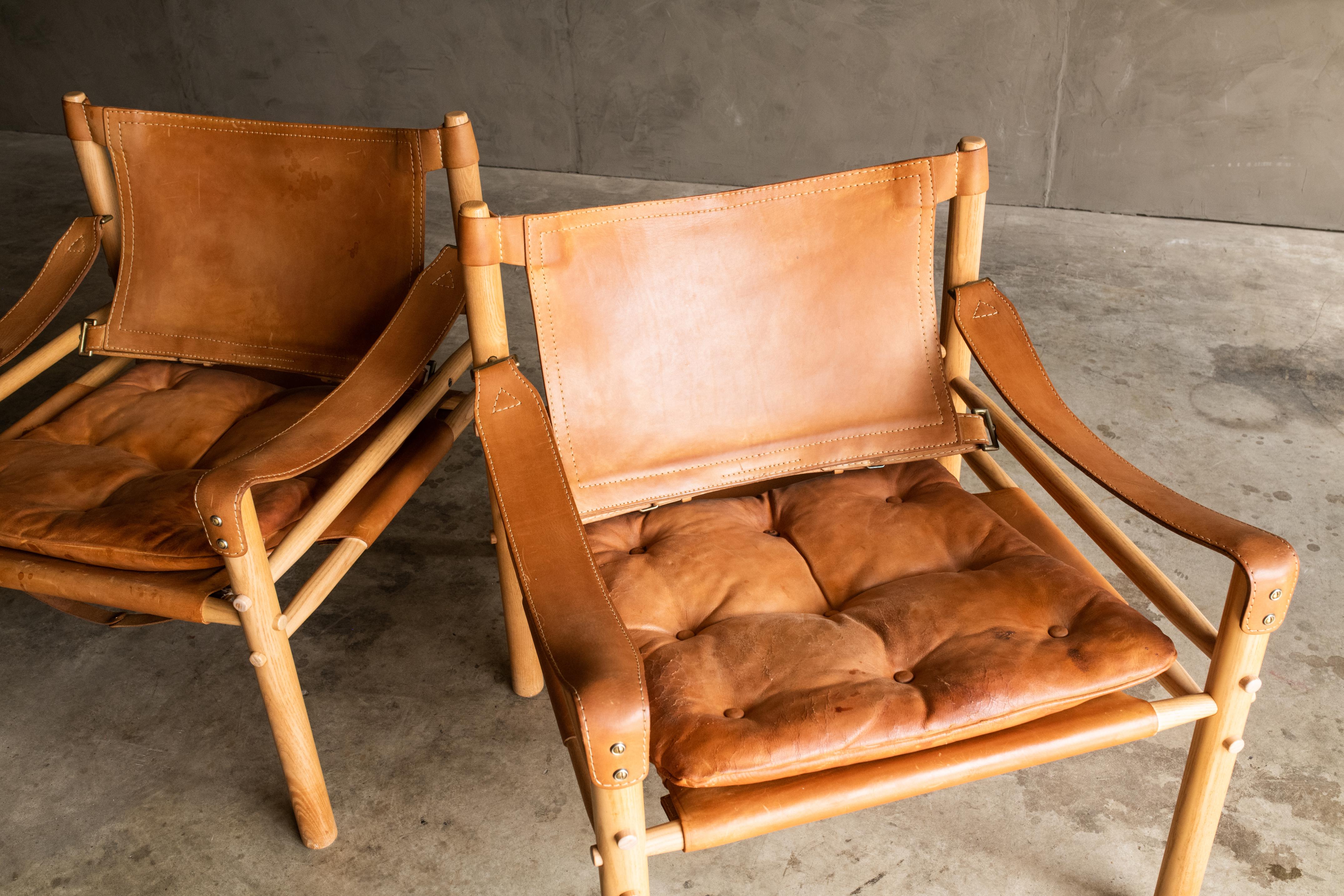 Pair of Arne Norell Safari lounge chairs, Model Sirocco, Sweden, 1970s. Original cognac leather with nice wear and patina.