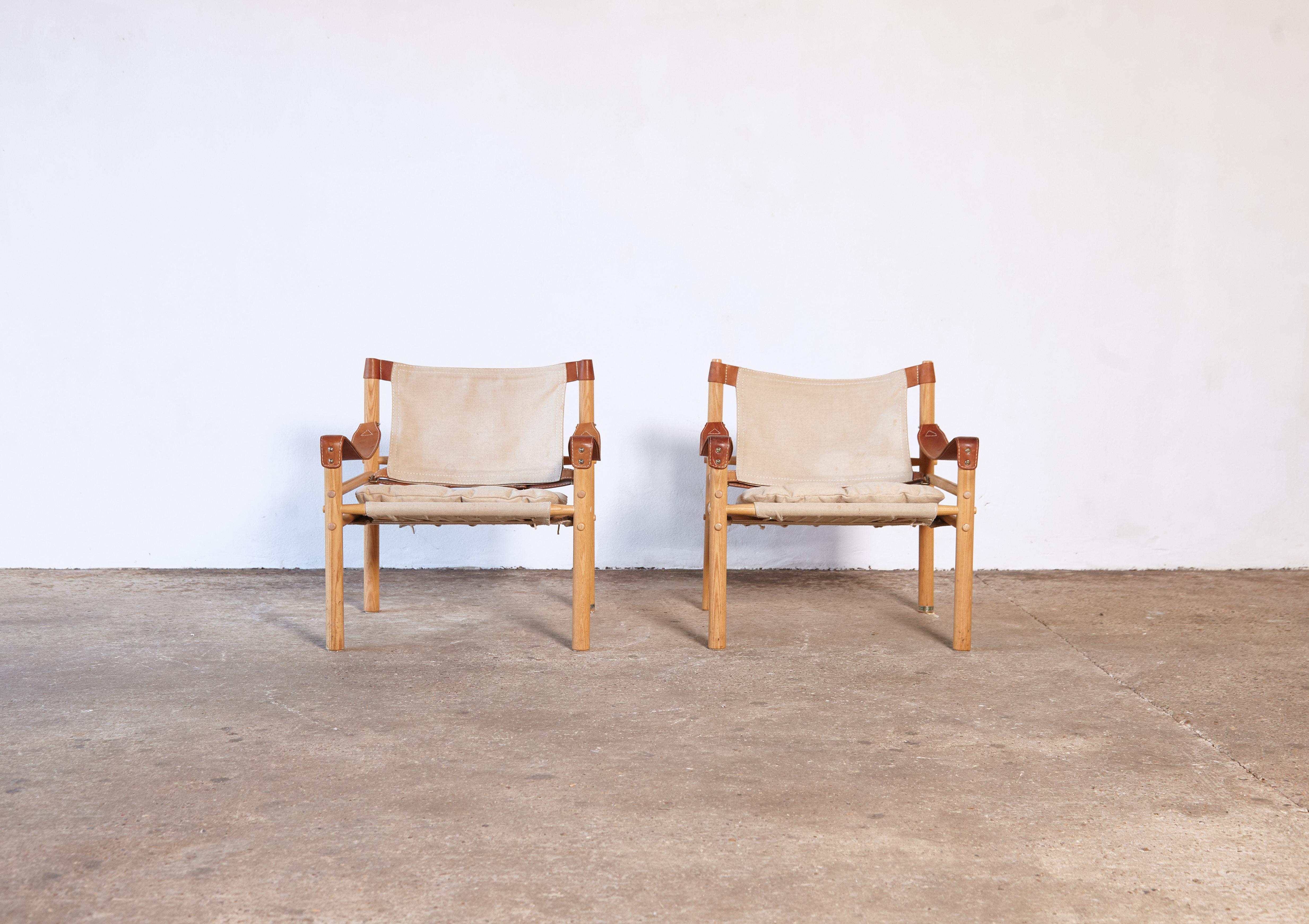 A pair of Arne Norell safari sirocco chairs in ashwood and original canvas. Made by Norell Möbel AB, in Sweden. Good original vintage condition with some minor signs of age related use and wear and some minor marks to canvas as seen in final