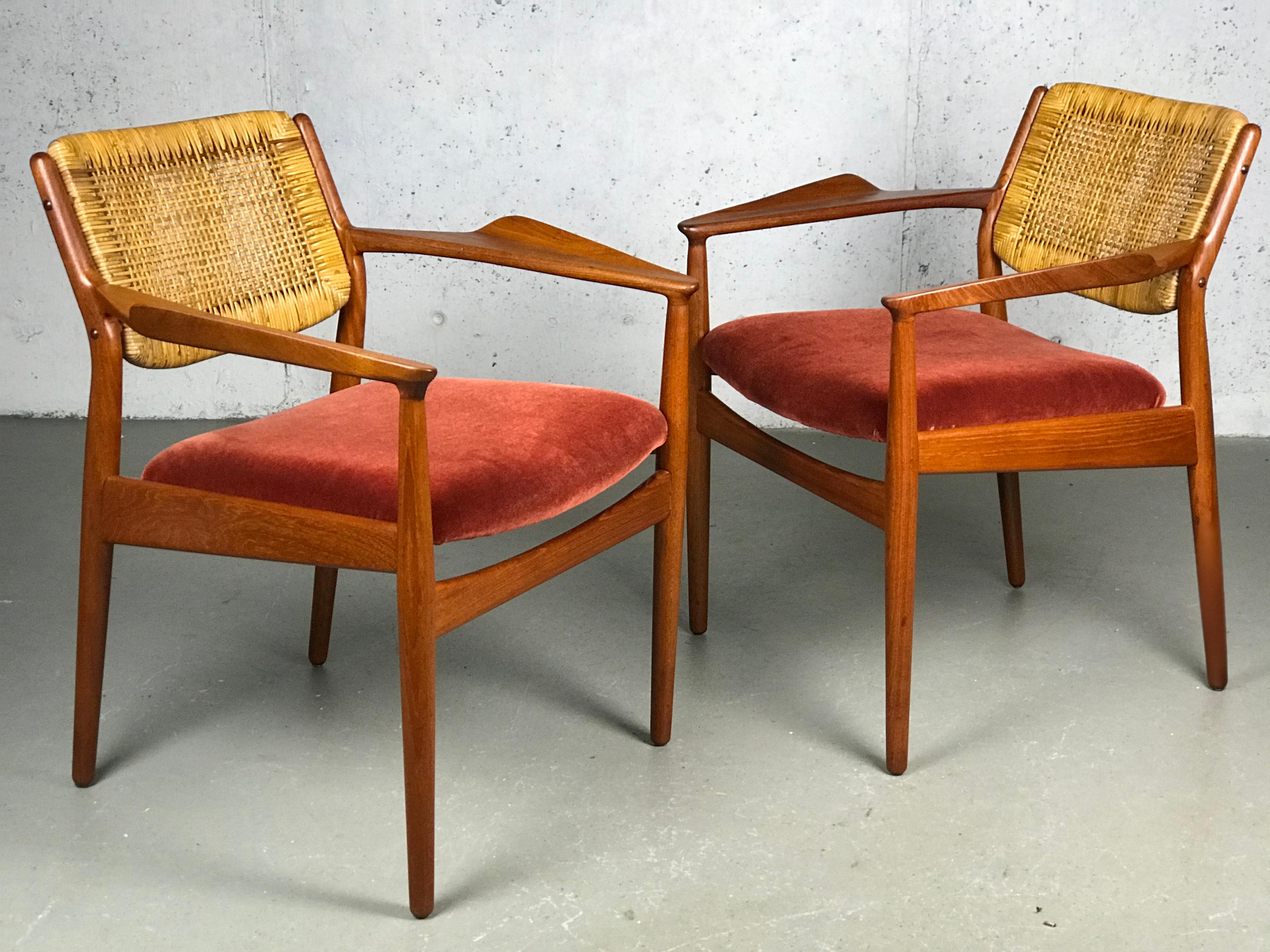 A pair of sculptural armchairs by Arne Vodder for Sibast; imported by George Tanier. Made of beech, cane & burgundy velvet fabric. I love the nicely sculpted and flared armrests; Arne Vodder's work reflects the training of his mentor, Finn Juhl.