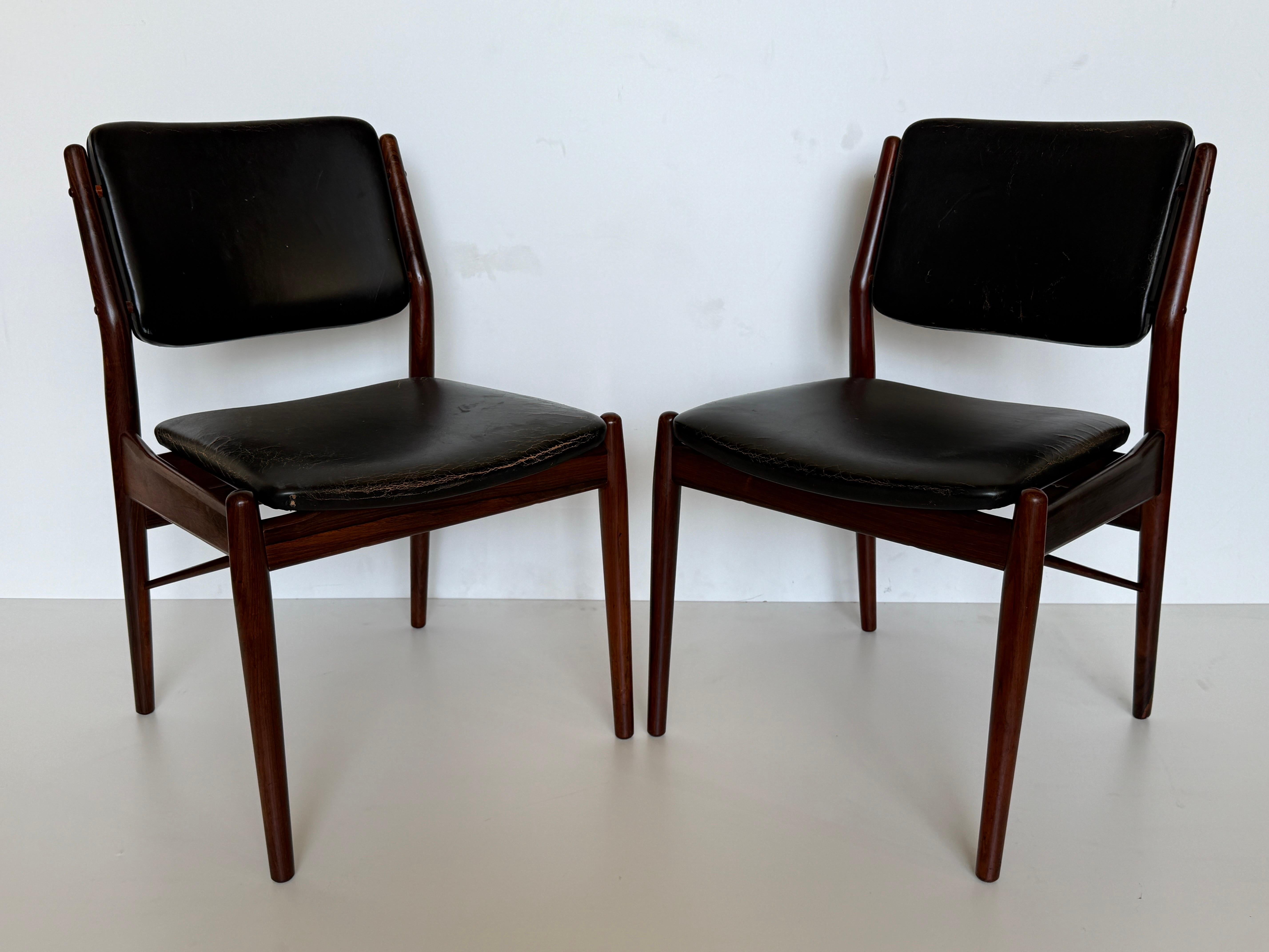 Pair of Arne Vodder designed side chairs for Sibast Mobler. These chairs are made of rare solid rosewood and retain original black leather upholstery. Leather upholstery has some cracks and natural patina. We left original leather as is which is