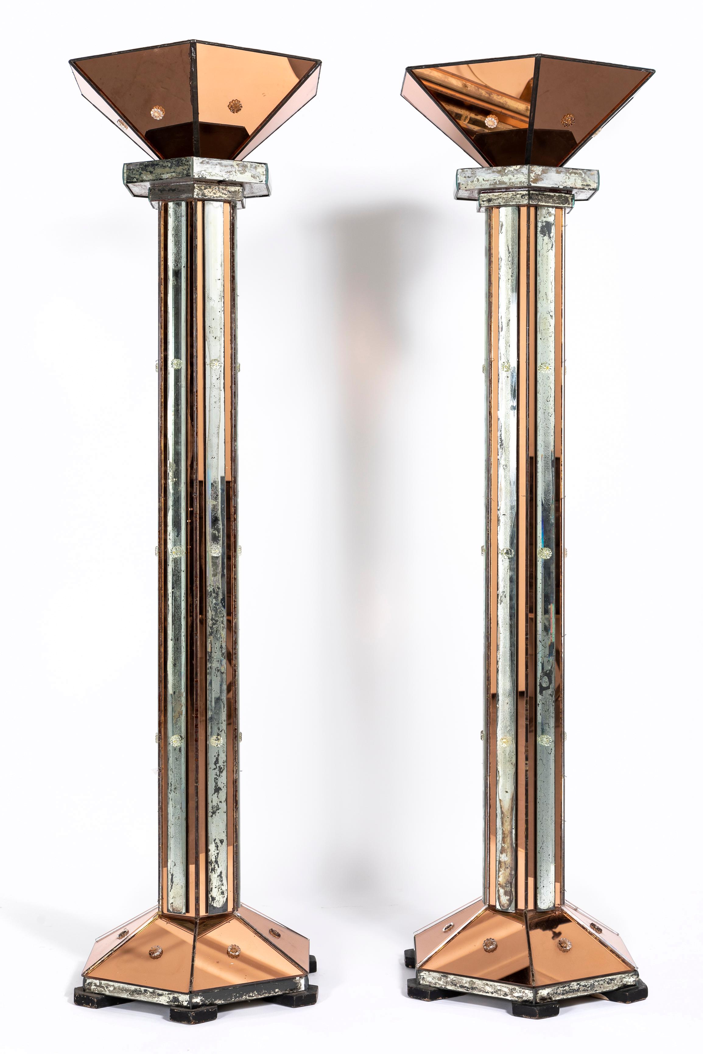 Magnifica coppia di lampade da terra a specchio bicolore del periodo Art Déco/Metà secolo, attribuite alla Maison Jansen.  Ogni lampada da terra è decorata con uno specchio color rame antico e uno specchio color argento antico.  Gli specchi sono