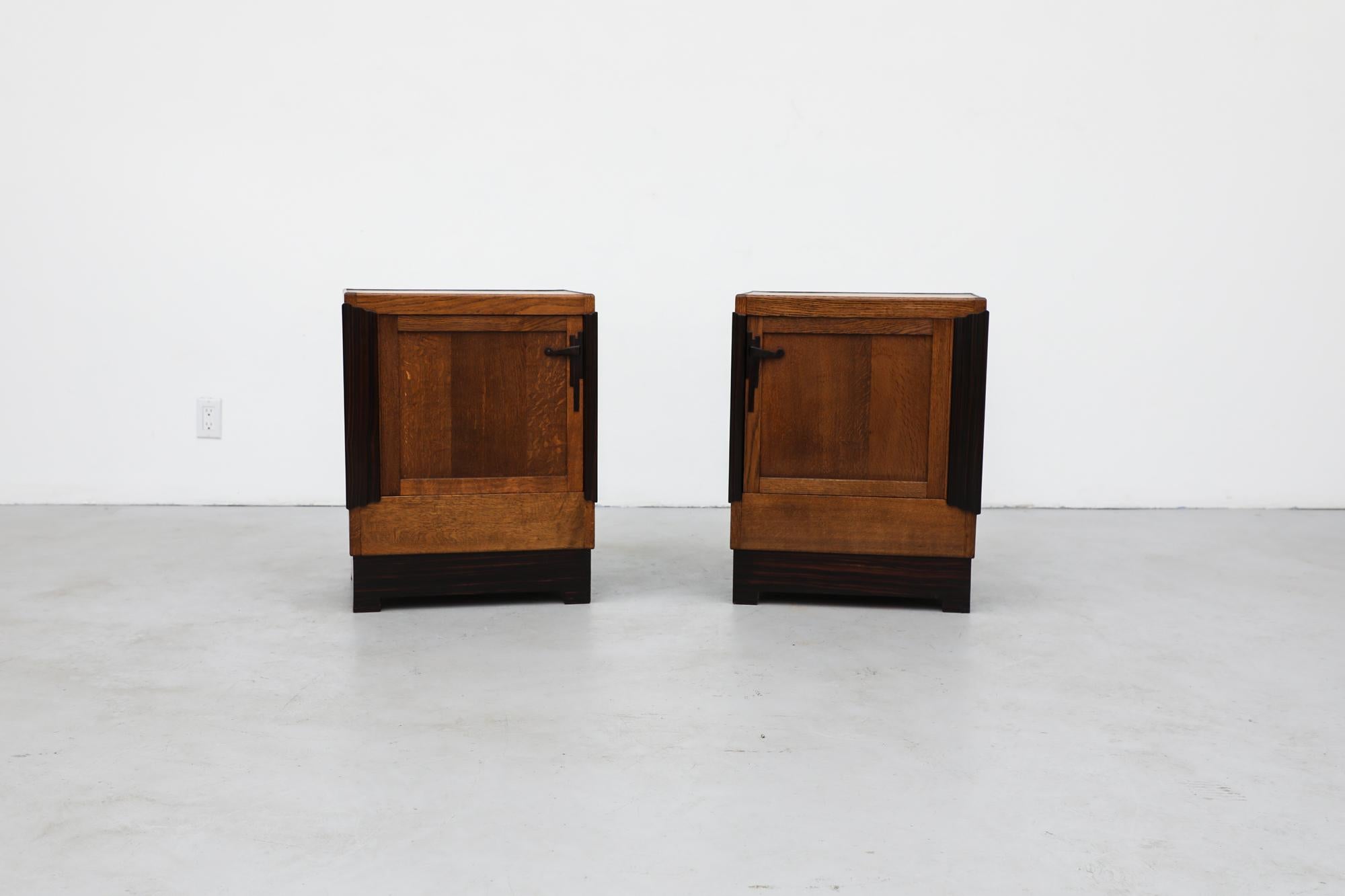 Pair of Art Deco cabinets each with single door and inner shelves. These delicate cabinets have an oak body with ebony and cocobolo accents. One has wood blocks glued inside on the floor of the cabinet, the use and reason are unknown. The vibrant