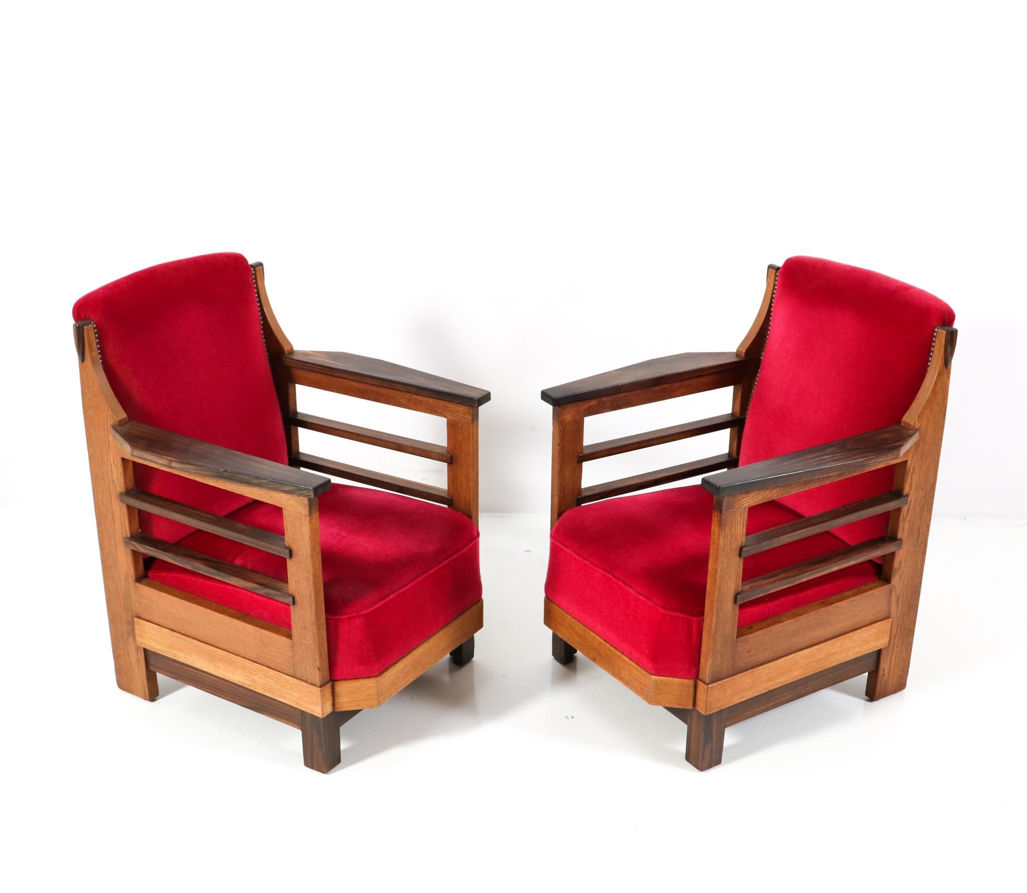 Prächtiges und seltenes Paar von Art Deco Amsterdamse School Lounge Stühlen. Entwurf von Anton Lucas für N.V. Meubelkunst Leiden. Auffälliges niederländisches Design aus den 1920er Jahren. Rahmen aus massiver Eiche mit Armlehnen aus massivem