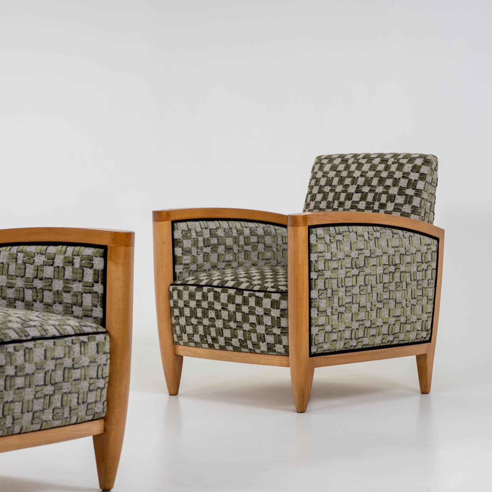 Paire de fauteuils Art Déco avec des cadres en bois clair et des accoudoirs subtilement courbés. Récemment rembourrées et méticuleusement polies à la main, ces chaises présentent un charmant tissu vert à carreaux. Le tissu présente une texture
