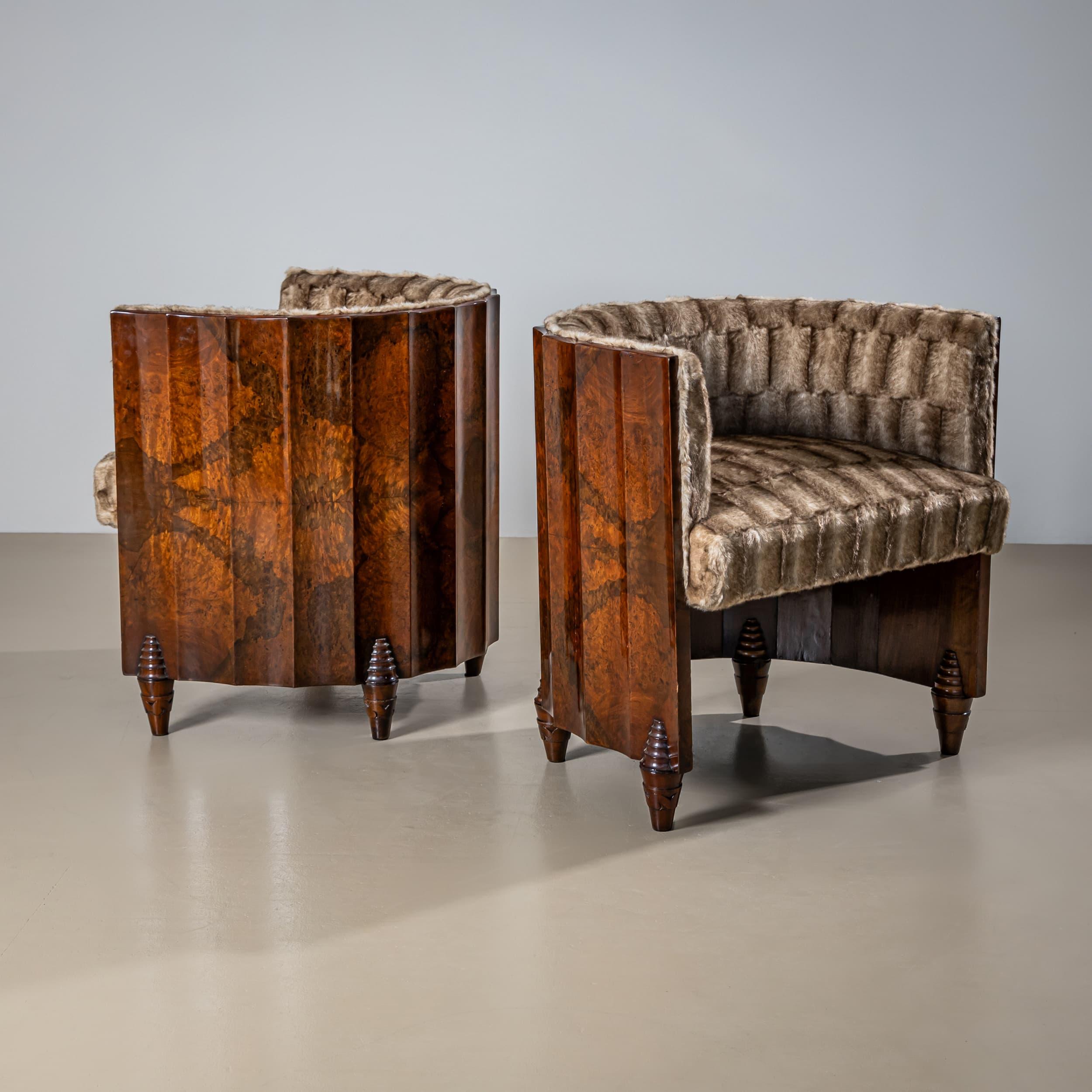 Pareja de sillones con armazón chapado festoneado de forma semicircular y patas cónicas con detalles escalonados. Las sillas están chapadas en nogal y se han pulido a mano. Se han tapizado de nuevo con una tela de piel sintética marrón.