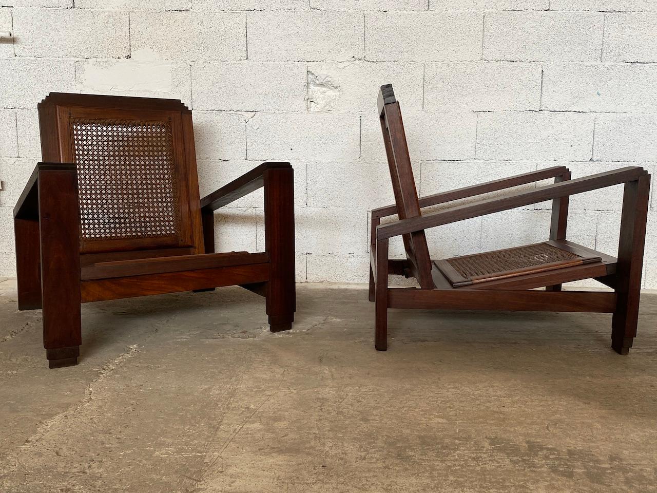 Pair of French Art Deco 1930 colonial armchairs in solid mahogany, caned seats and backs in good condition. Rocking back and seats. From a plantation in the Ivory Coast. 
In the taste of chandigarh. 
Measures: Seat height 27 cm.
H83 x L72 x P77.