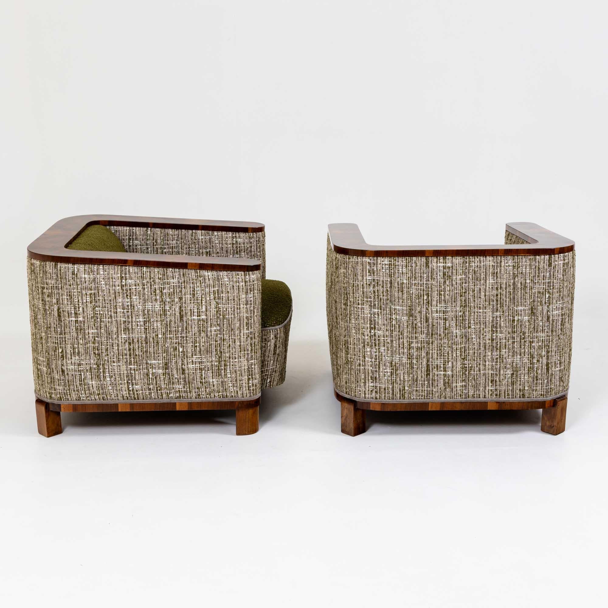 A pair of Art Deco club chairs with foot stools. 
Chairs & foot stools detailed in walnut veneer.