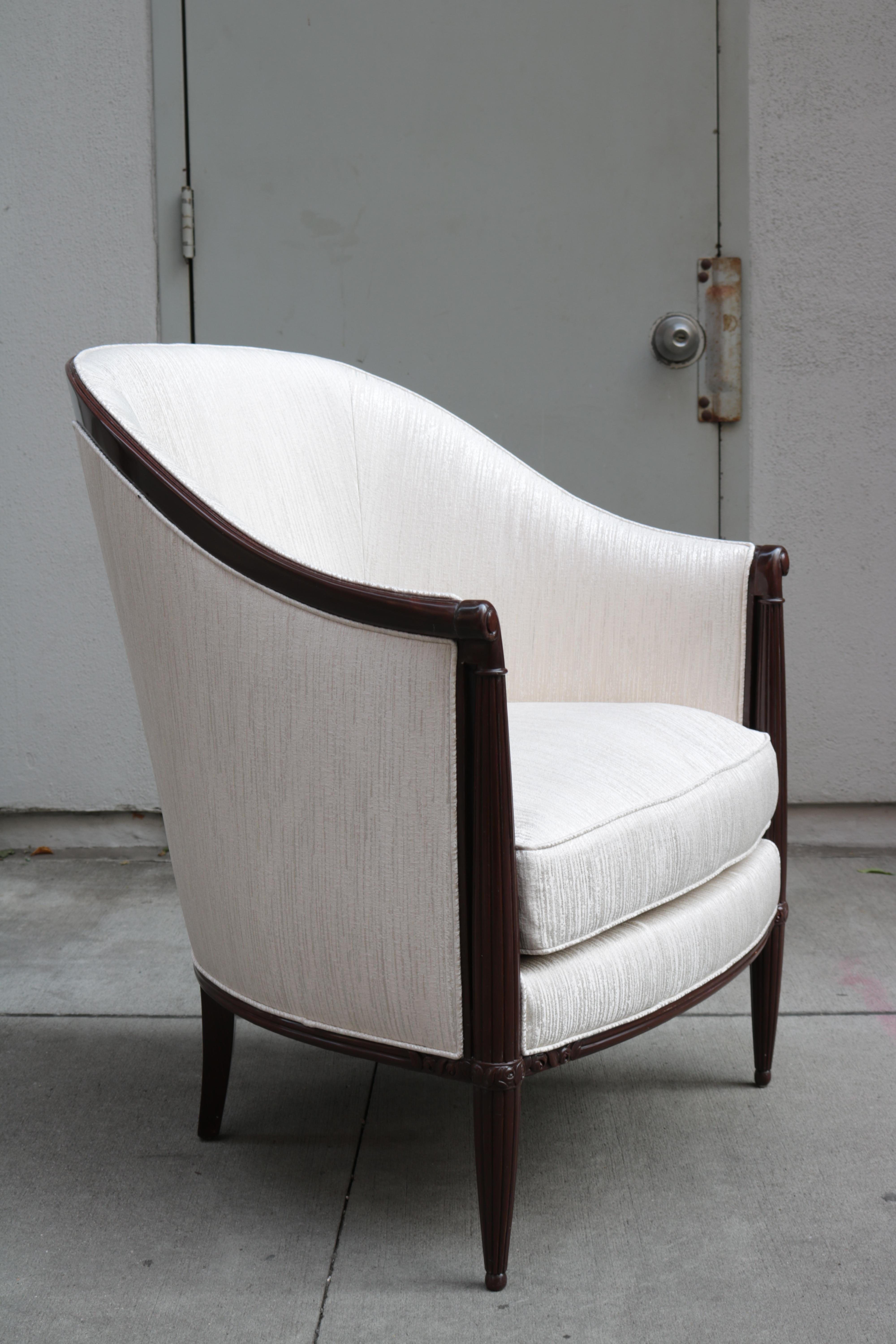 A pair of Art Deco Armchairs with carved details and fluted front legs.