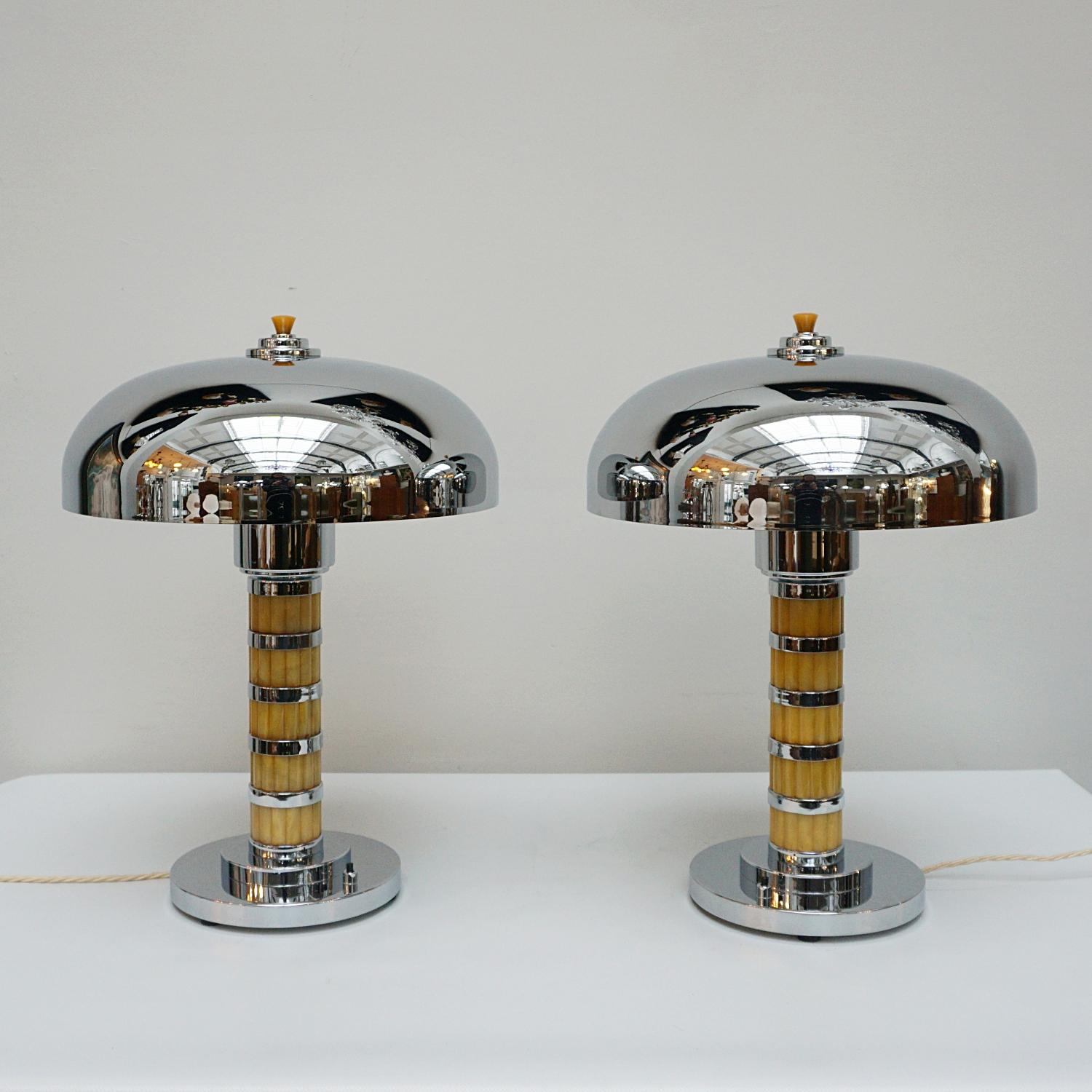 A pair of Art Deco style dome lamps. Yellow fluted bakelite stem with chrome banding, over a chromed metal circular base and a chromed metal shade. Chrome finial to top. 

Dimensions: H 50cm W 20cm, Depth of Shade: 38cm

Origin: English

Item