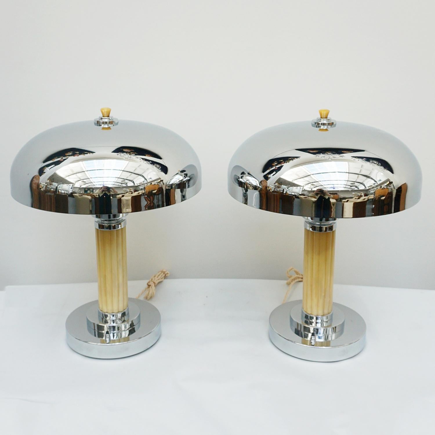 A pair of Art Deco dome lamps. Fluted yellow stem with over a chromed metal circular base and a chromed metal shade. Yellow bakelite finial to top. 

Dimensions: H 48cm, D of shade 37cm, D of base 20cm.

Origin: English

Item Number: