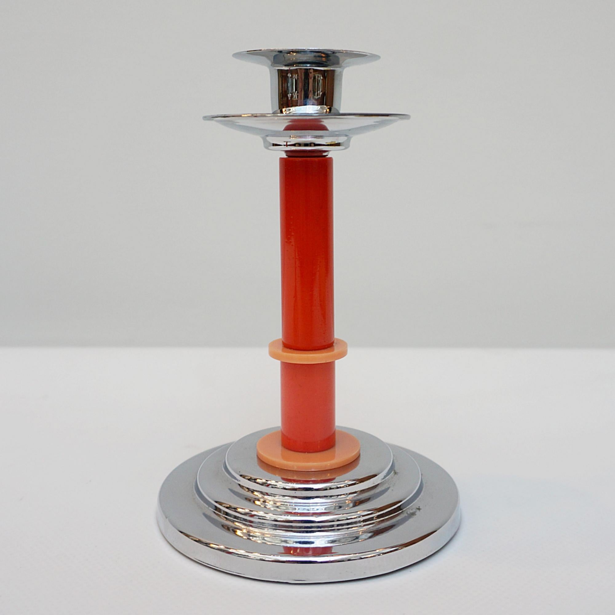 A pair of Art Deco style candlesticks. Red and orange dual ringed bakelite stem with chromed metal wax pan. Set over a rounded, stepped chromed metal base with cork insert. 

Dimensions: H 15.5cm W 10cm

Origin: English

Item Number:
