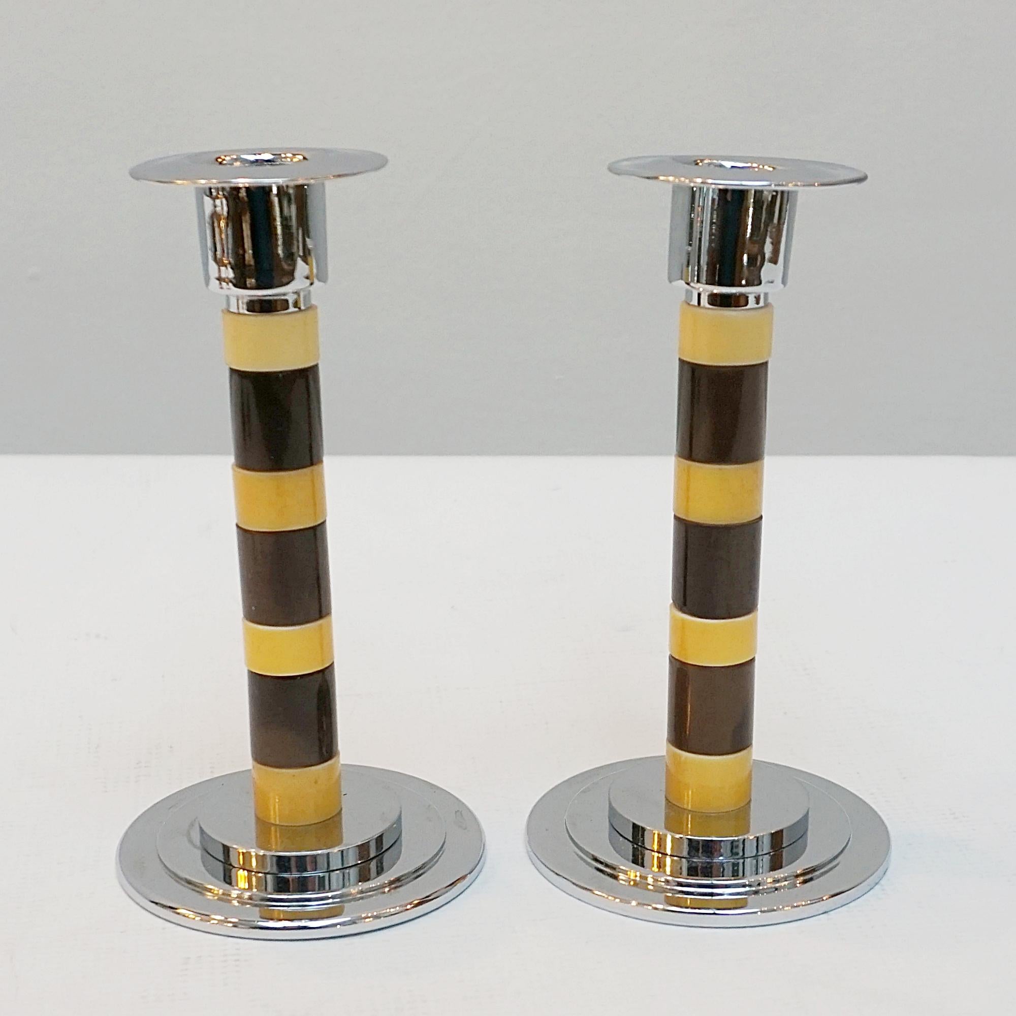 A pair of Art Deco style candlesticks. Brown and yellow dual ringed bakelite stem with chromed metal wax pan. Set over a rounded, stepped chromed metal base.

Dimensions: H 14cm W 7.5cm

Origin: English

Item Number: 2212233

Re-chromed and polished