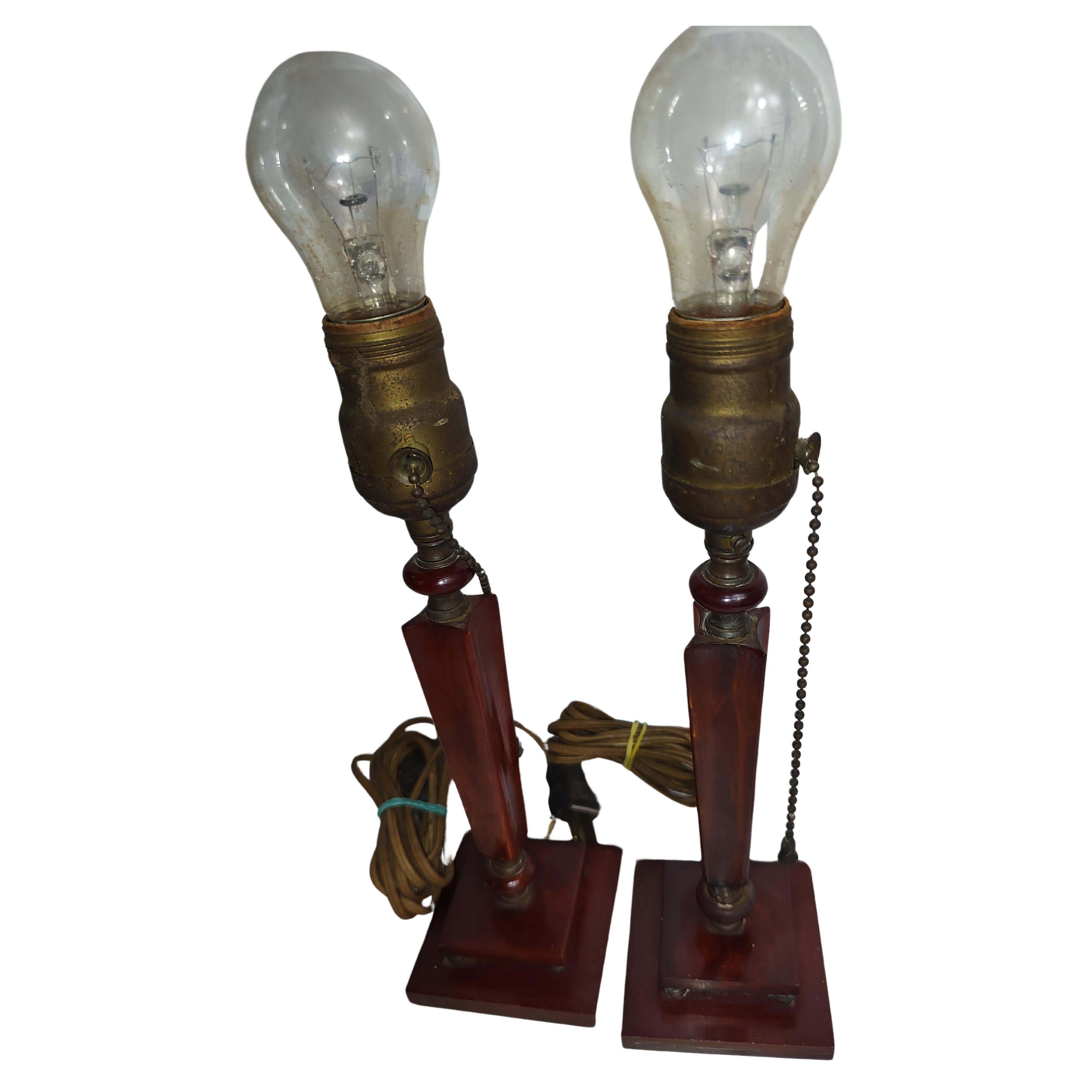 Fabulous pair of Mid Century Art Deco Sculptural Bakelite table lamps. Cherry amber in color which did not photograph well. In excellent vintage condition with minimal wear. Tin Shades are perfect.